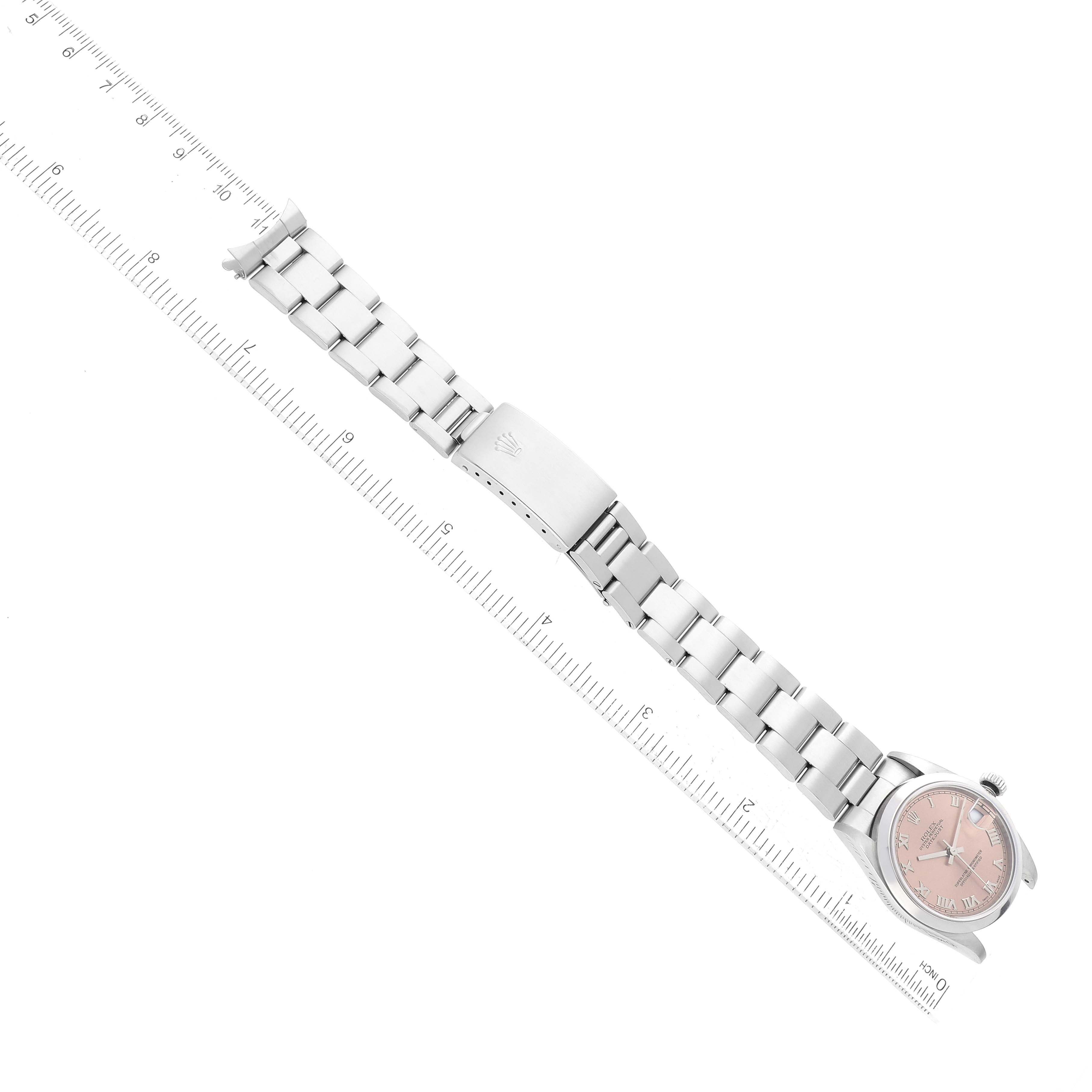 The image shows a full view of a Rolex Mid-Size 78240 Women's Stainless Steel Pink Dial 78240 Women's Stainless Steel Pink Dial watch, including its dial, bracelet, and clasp, positioned diagonally alongside a ruler.
