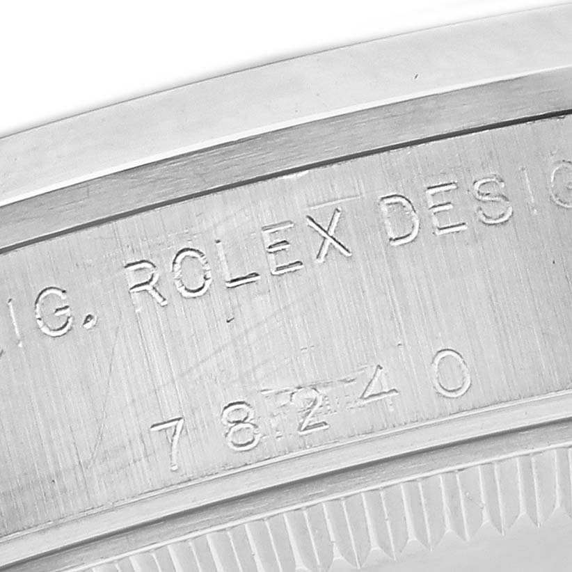 This image shows a close-up of the side of a Rolex Mid-Size 78240 Women's Stainless Steel Silver Dial 78240 Women's Stainless Steel Silver Dial watch, highlighting the engraved serial and model numbers.
