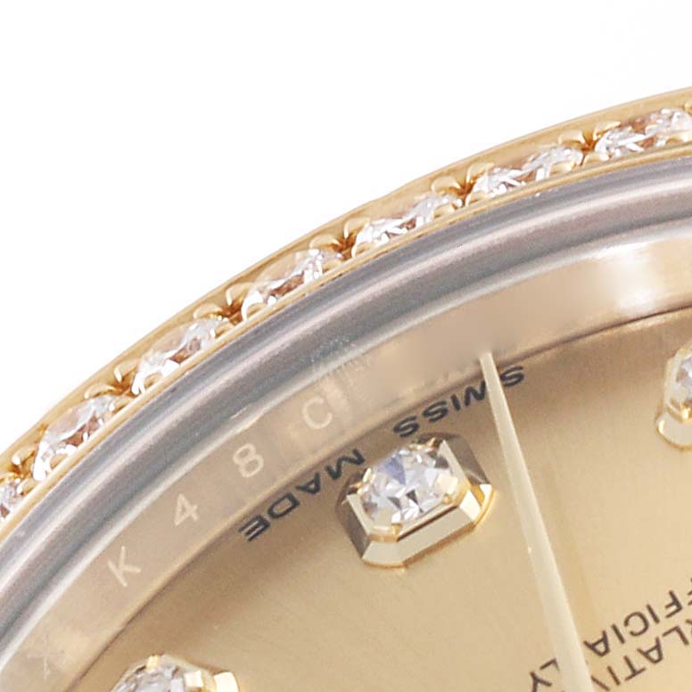 This close-up of a Rolex Mid-Size 178383 Women's Steel and Gold (two tone) Champagne Dial 178383 Women's Steel and Gold (two tone) Champagne Dial model watch shows the diamond-studded bezel, part of the dial, and the "Swiss Made" text.