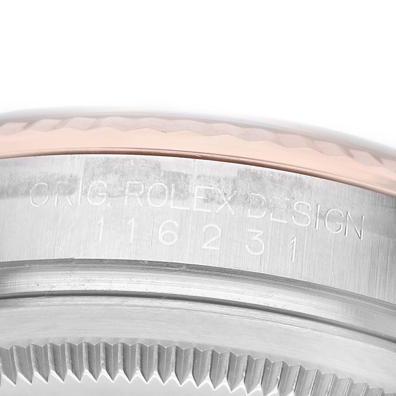The image shows a close-up of the side of a Rolex Datejust 116231 Men's Steel and Gold (two tone) White Dial, focusing on the engraved design and serial numbers on the case.