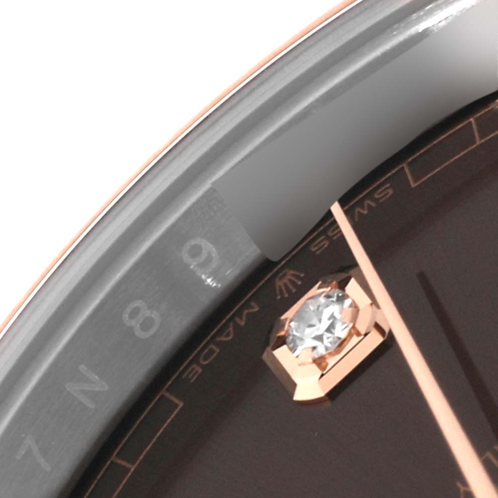 This close-up image of the Rolex Datejust 41 126301 Men
s Steel and Gold (two tone) Brown Dial 126301 Men
s Steel and Gold (two tone) Brown Dial watch shows part of the dial with a diamond hour marker and the rehaut with the engraved serial number.
