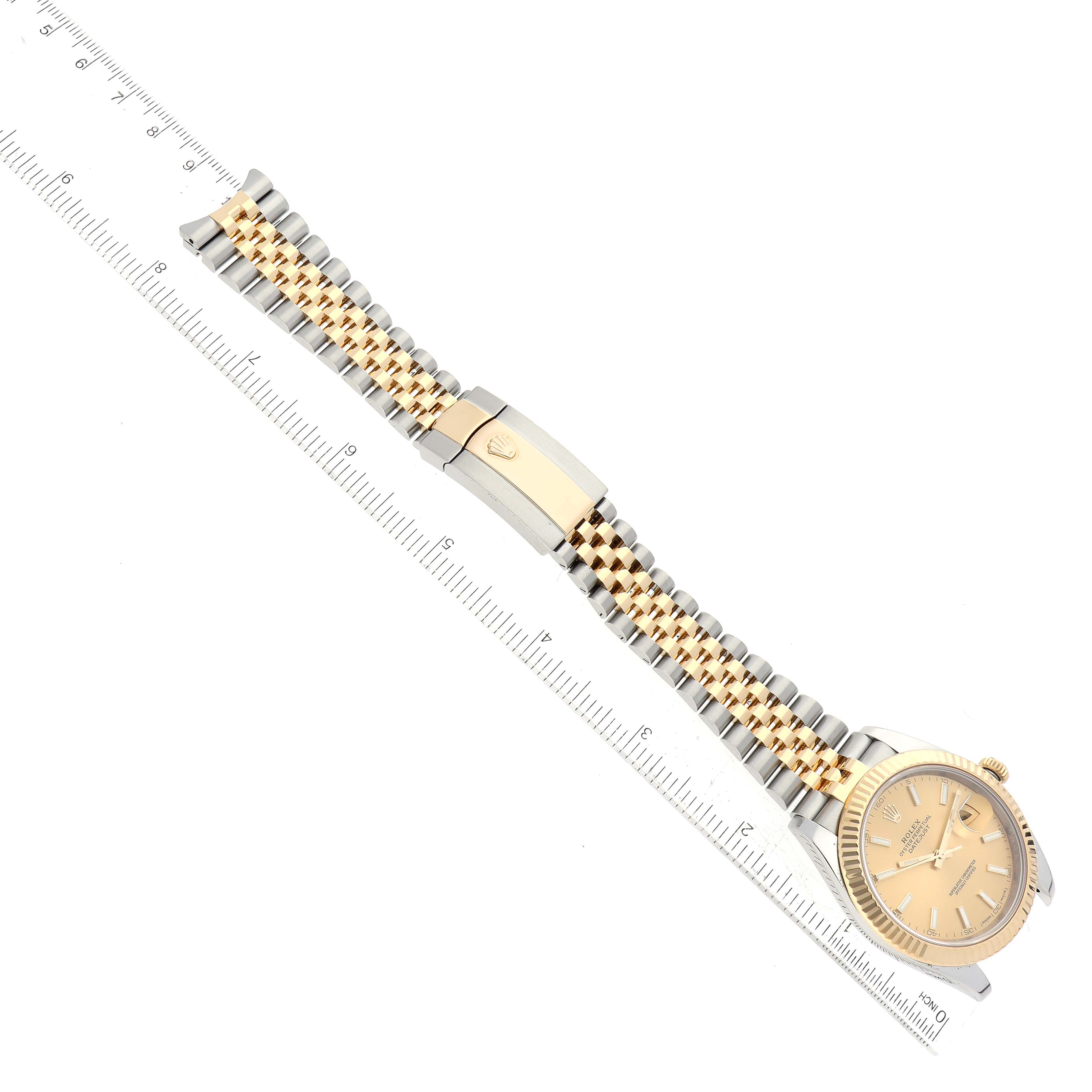 This is an overhead view of a Rolex Datejust 41 126333 Men's Steel and Gold (two tone) Champagne Dial 126333 Men's Steel and Gold (two tone) Champagne Dial watch, showing the dial, bracelet, and clasp with a measuring ruler for scale.