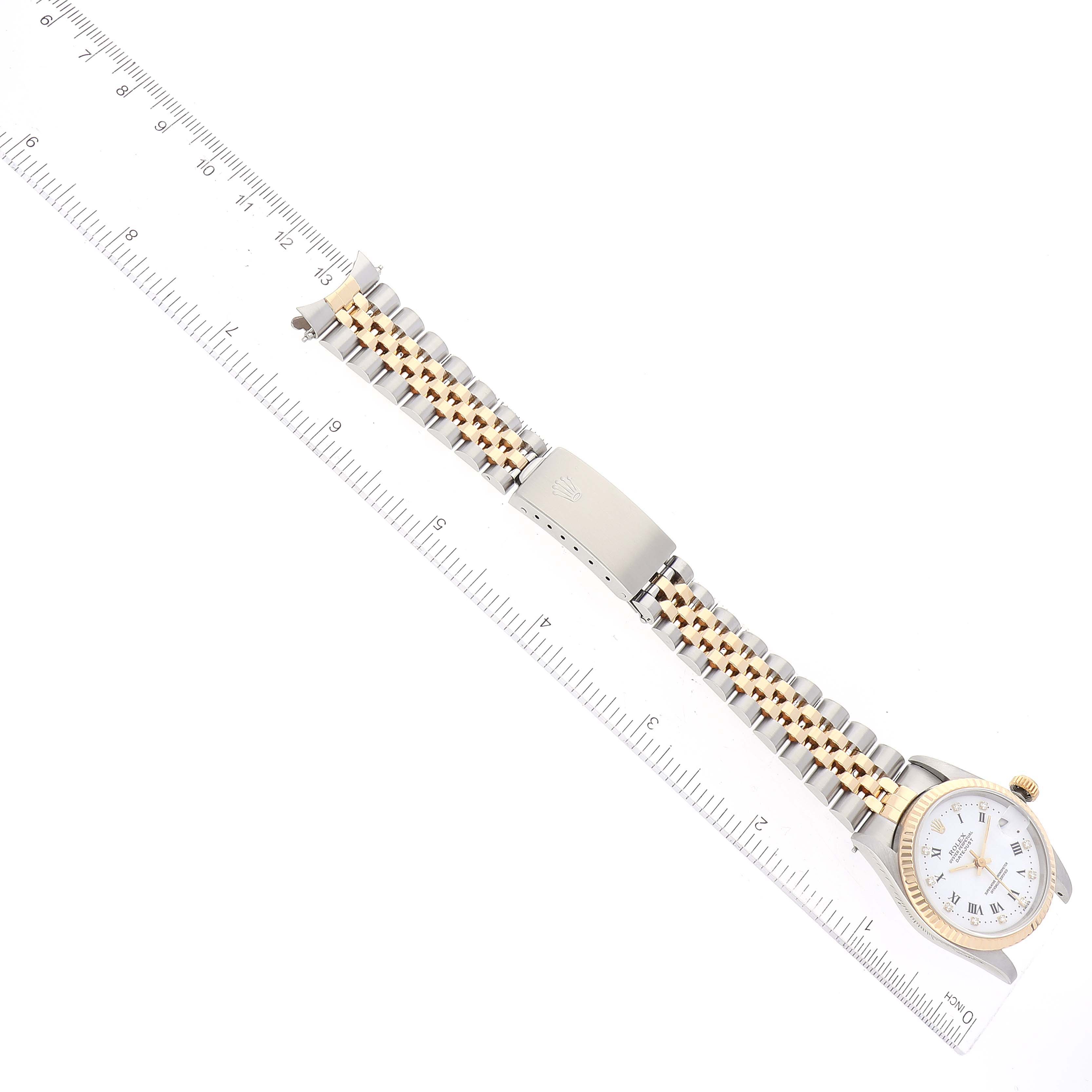 The Rolex Mid-Size 68273 Women's Steel and Gold (two tone) White Dial 68273 Women's Steel and Gold (two tone) White Dial model watch is shown from a top-down angle, highlighting the dial, bracelet, and clasp, with a ruler for scale.