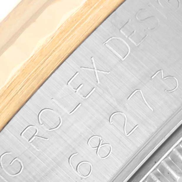 This close-up shows the engraved side of a Mid-Size Rolex watch case with part of the model number visible.