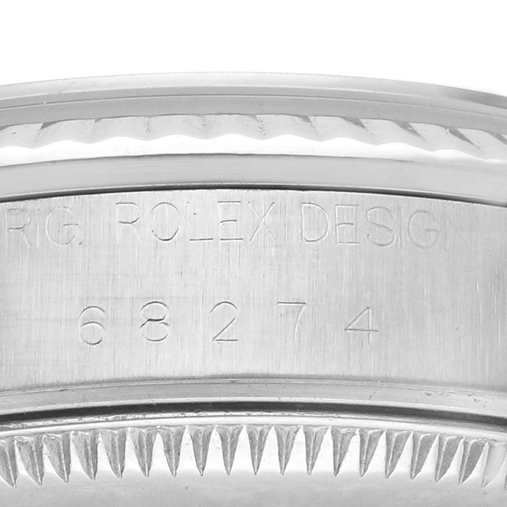 This image shows a close-up of the side of a Rolex Mid-Size 68274 Women's Stainless Steel Blue Dial 68274 Women's Stainless Steel Blue Dial model watch, highlighting the engraved serial number and "Rolex Design" text.