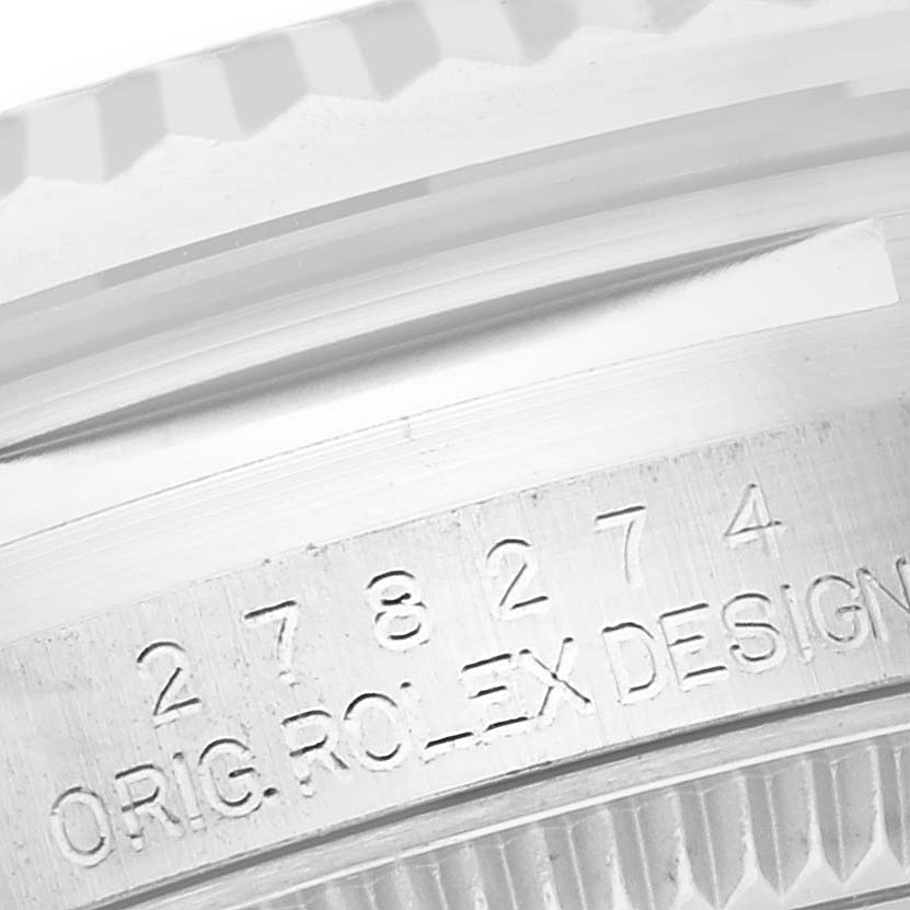 This close-up image shows the case edge and part of the bezel of a Rolex Mid-Size 278274 Women's Stainless Steel White Dial 278274 Women's Stainless Steel White Dial model, with engraved text and numbers.