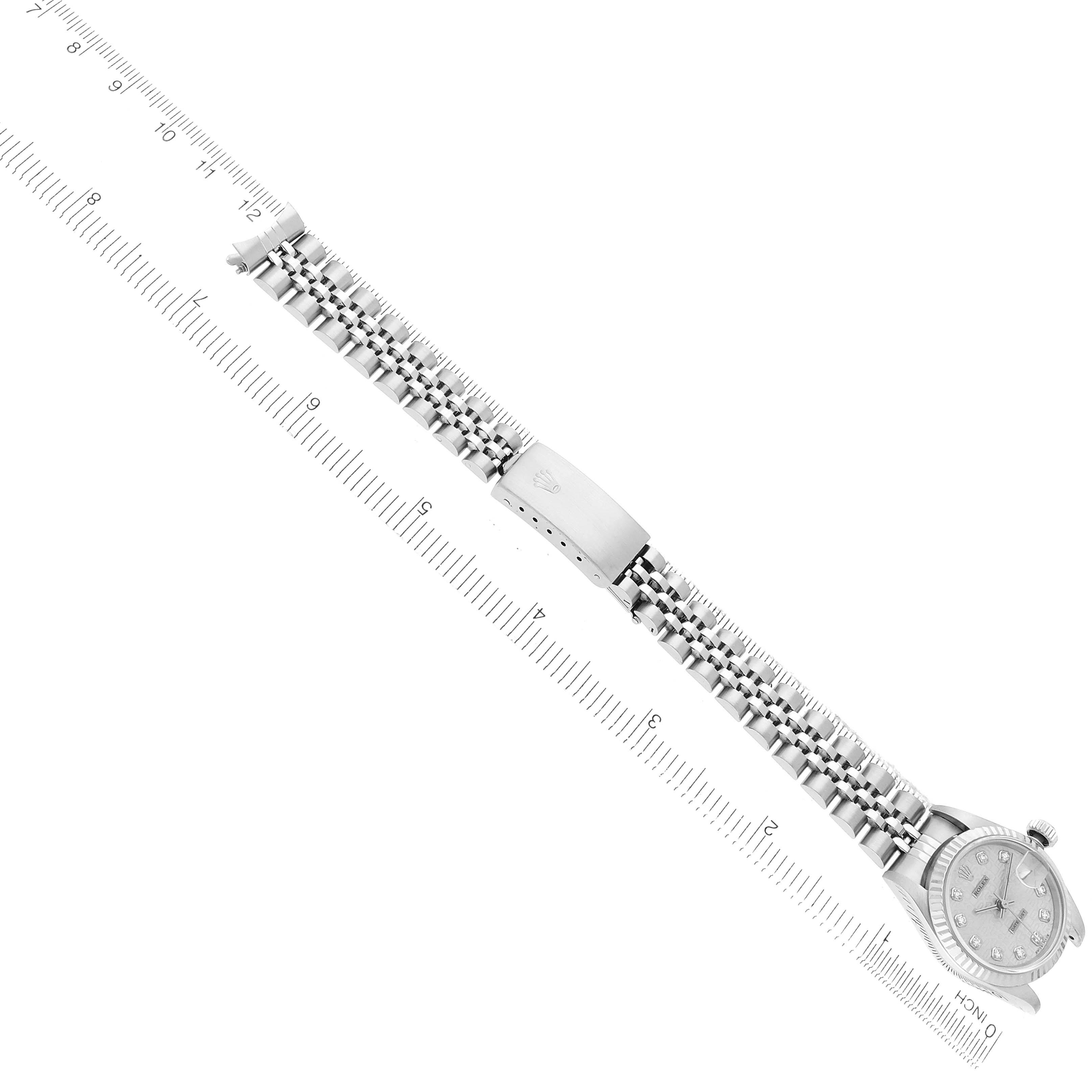 The image shows a Rolex Datejust 69174 Women's Stainless Steel Silver Dial watch at an angle, highlighting the bracelet and clasp, alongside a ruler for scale.