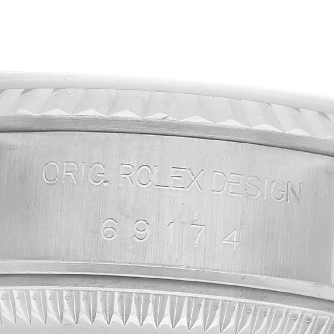 The image shows a close-up of the side of a Rolex Datejust 69174 Women's Stainless Steel Silver Dial with the engraving "ORIG. ROLEX DESIGN 69174."