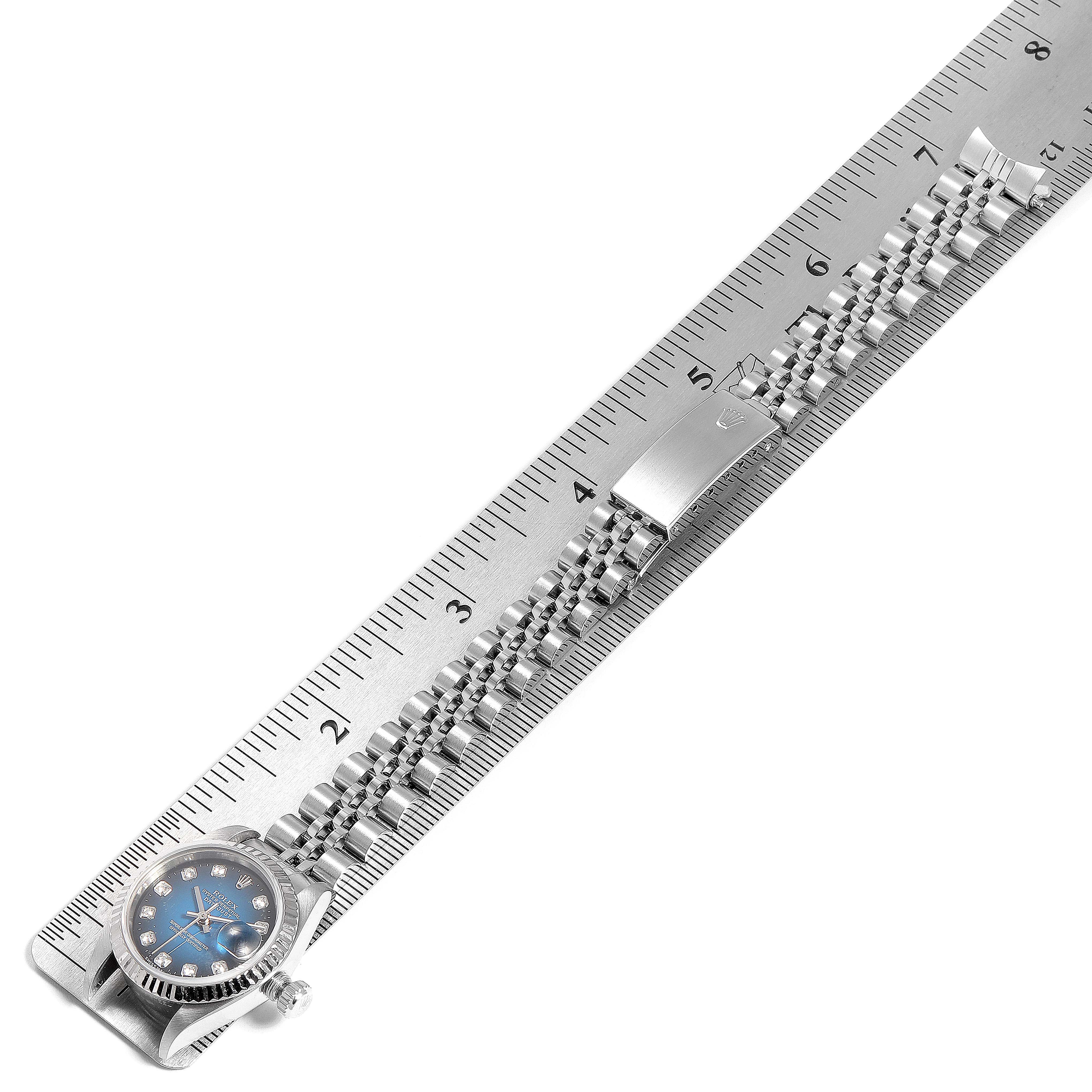 This image shows a Rolex Datejust 69174 Women's Stainless Steel Blue Dial 69174 Women's Stainless Steel Blue Dial watch laid flat with its Jubilee bracelet next to a ruler for measurement.