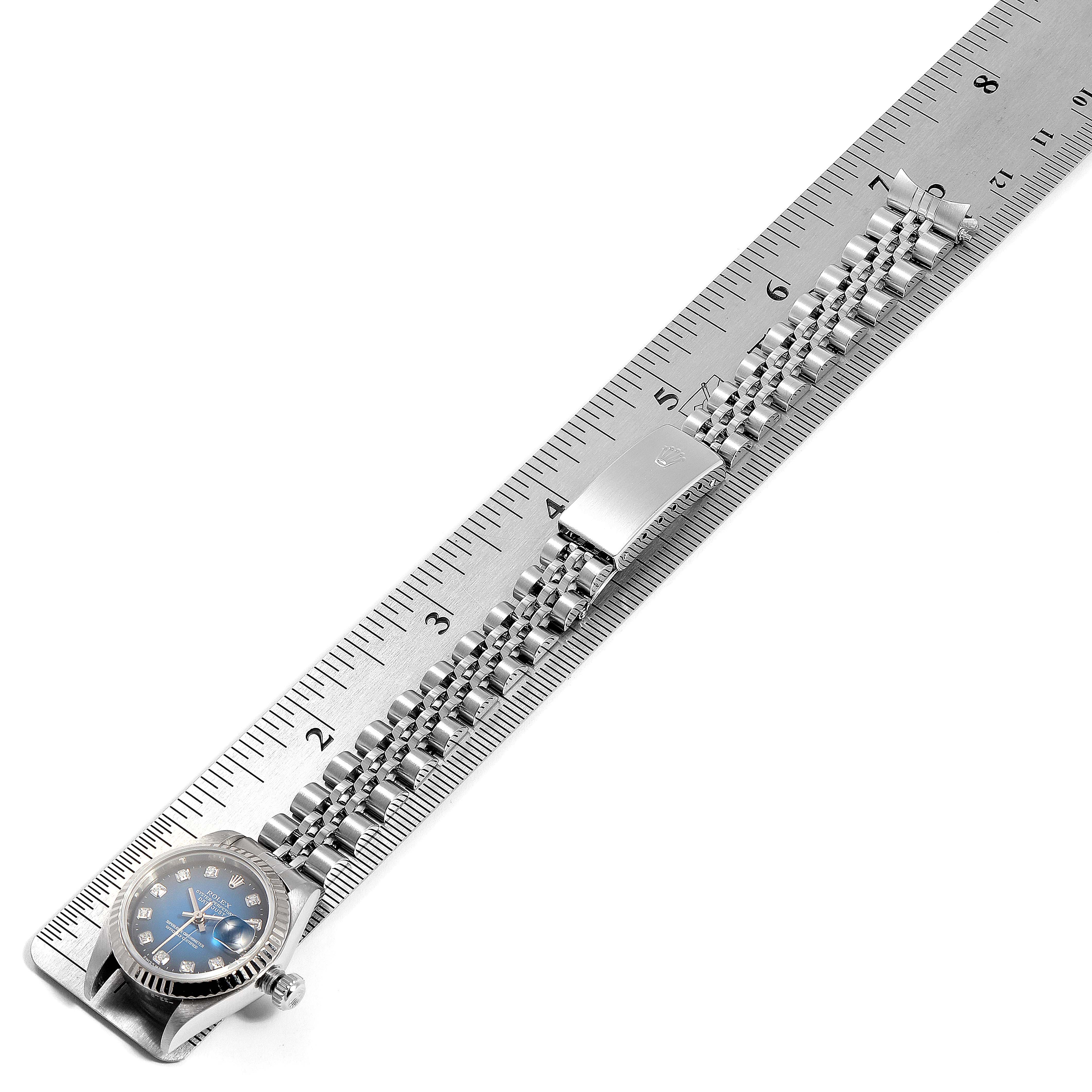 The Rolex Datejust 79174 Women's Stainless Steel Blue Dial 79174 Women's Stainless Steel Blue Dial watch is shown from a top angle, highlighting the face, bracelet, and clasp alongside a ruler for scale.