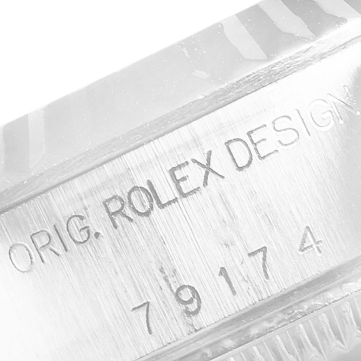 This image shows a close-up of the serial number engraving on the case of a Rolex Datejust 79174 Women's Stainless Steel Blue Dial 79174 Women's Stainless Steel Blue Dial watch.