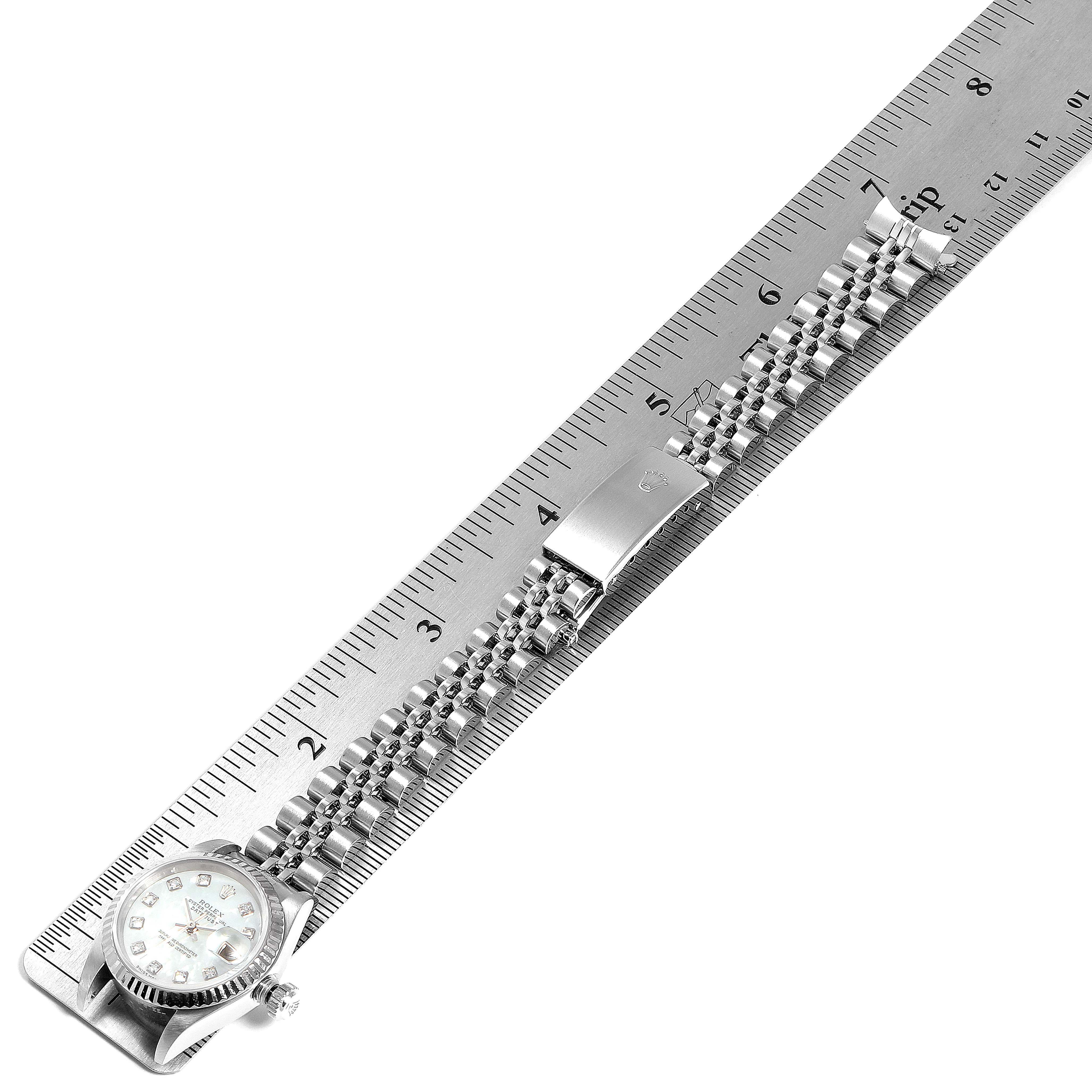 The image shows a top-down angle of a Rolex Datejust 79174 Women's Stainless Steel Mother of Pearl Dial 79174 Women's Stainless Steel Mother of Pearl Dial watch fully extended next to a ruler for measurement.