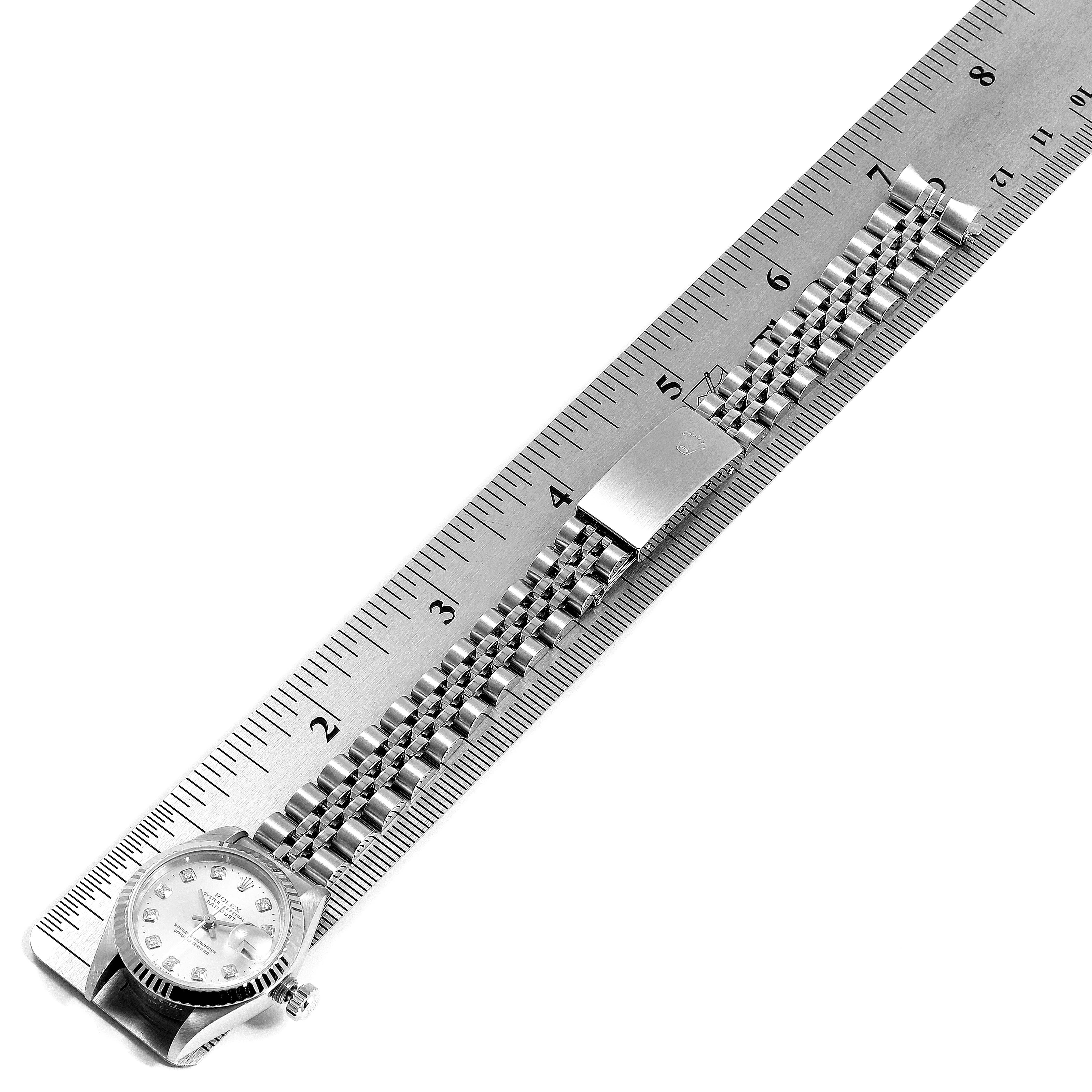 The Rolex Datejust 69174 Women
s Stainless Steel White Dial 69174 Women
s Stainless Steel White Dial watch is shown flat and fully extended, including the face and bracelet, laid along a ruler.