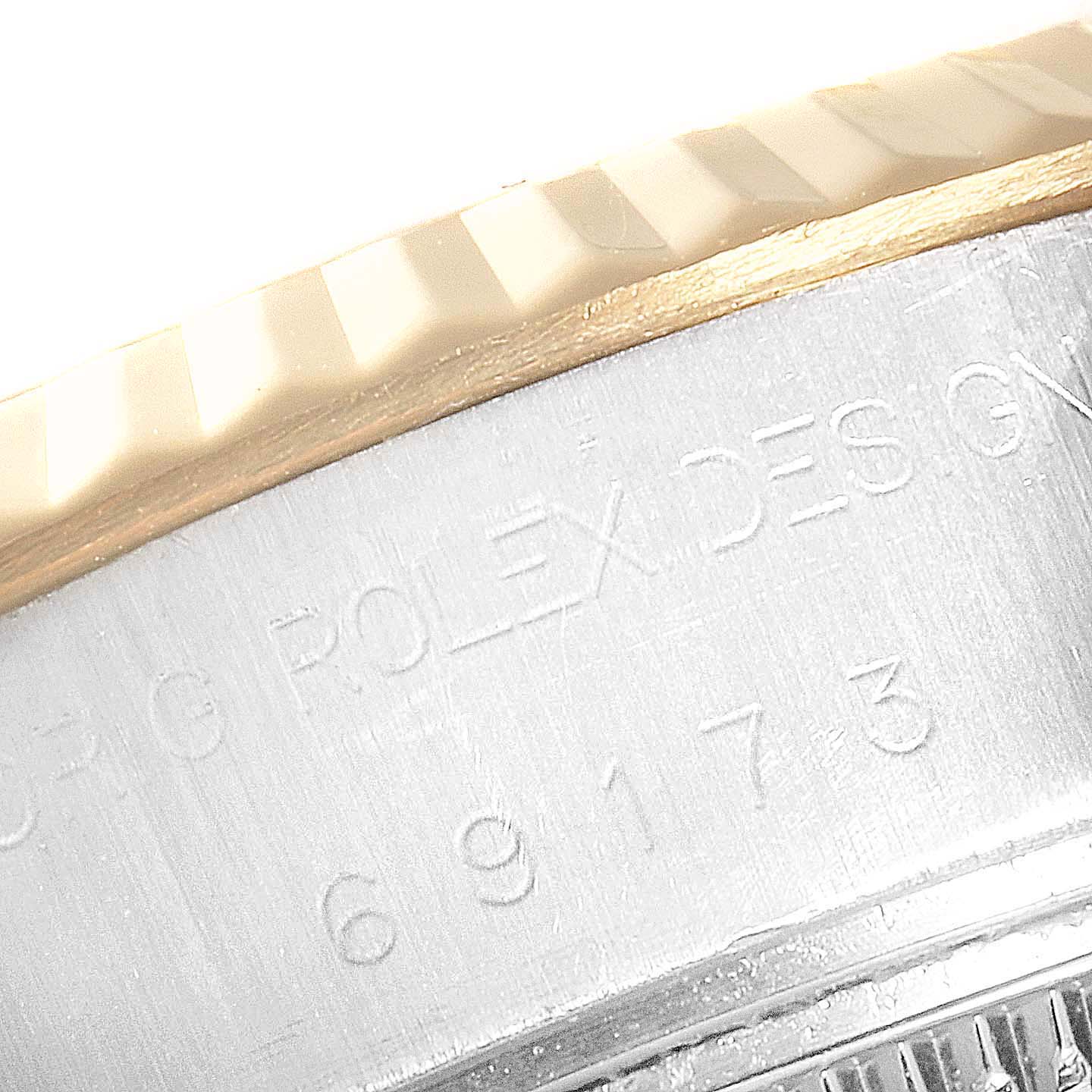 This image shows a close-up of the serial number and part of the fluted bezel of a Rolex Datejust 69173 Women
s Steel and Gold (two tone) White Dial 69173 Women
s Steel and Gold (two tone) White Dial watch.