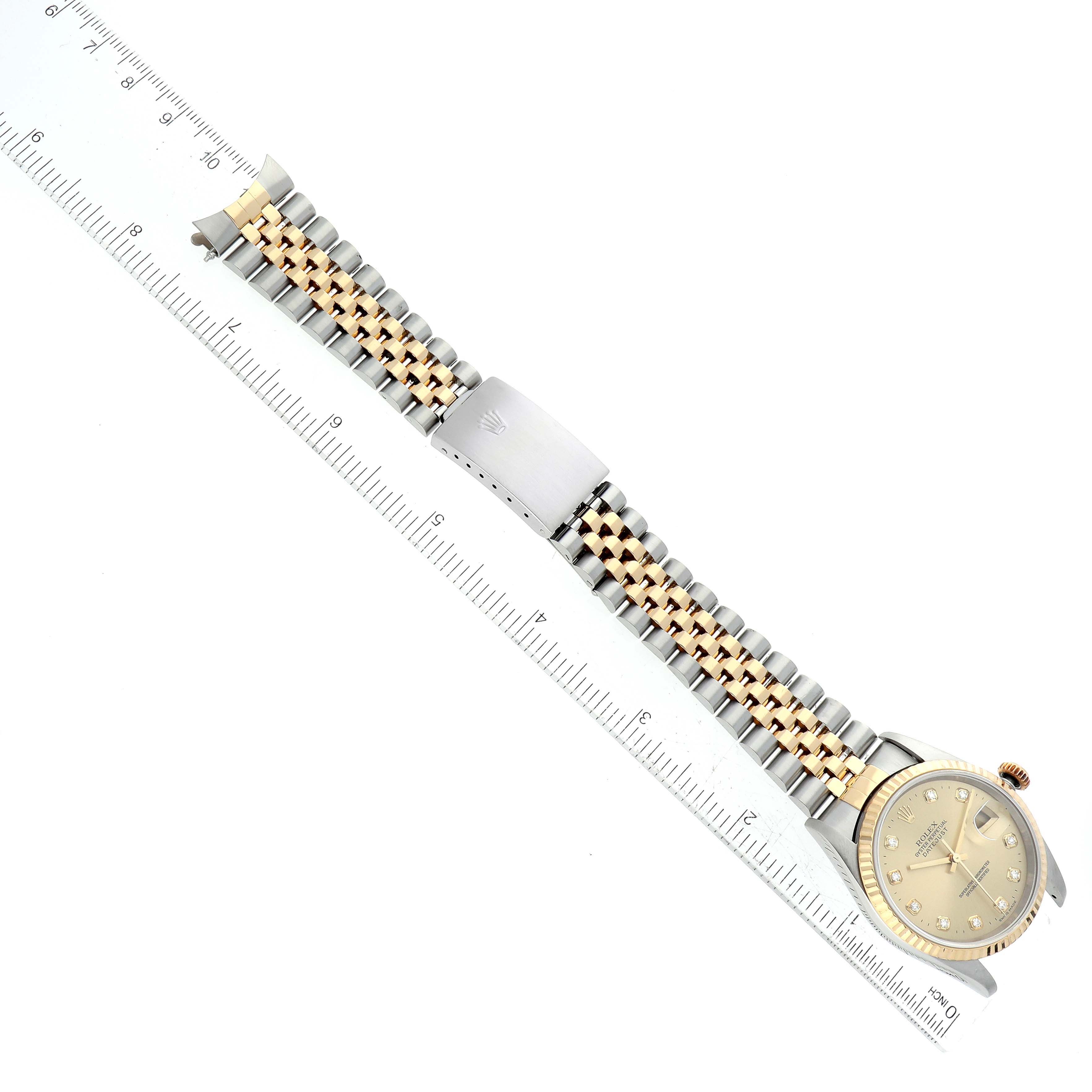 The image shows a Rolex Datejust 16233 Men
s Steel and Gold (two tone) Champagne Dial 16233 Men
s Steel and Gold (two tone) Champagne Dial watch laid flat with its bracelet extended and aligned with a ruler for measurement.