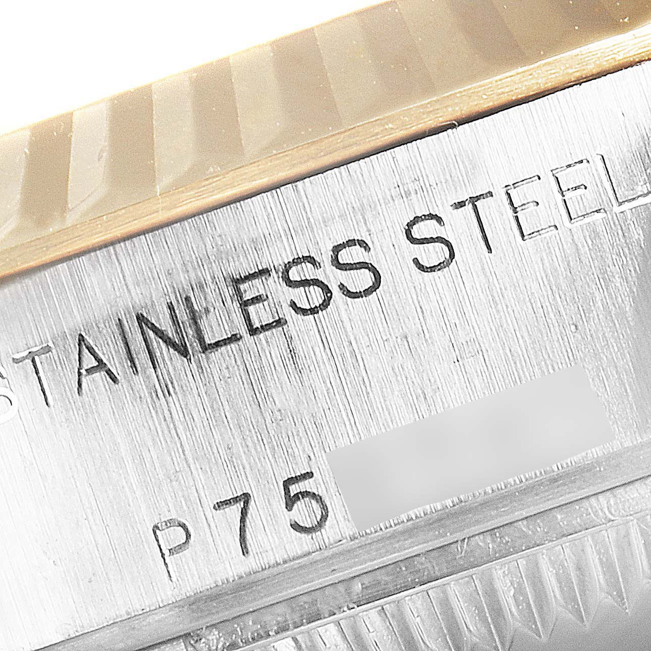 This close-up image of a Rolex Datejust 79173 Women
s Steel and Gold (two tone) White Dial 79173 Women
s Steel and Gold (two tone) White Dial watch shows part of the stainless steel case and the model number engraving.