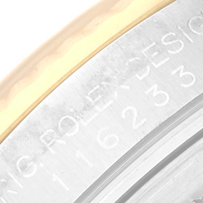 The image shows an angled close-up of the engraved bezel of a Rolex Datejust 116233 Men's Steel and Gold (two tone) Beige Dial 116233 Men's Steel and Gold (two tone) Beige Dial watch.