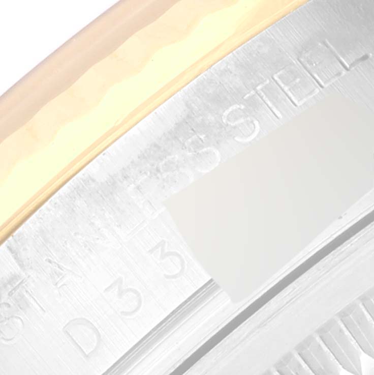 This close-up image shows part of the Rolex Datejust 116233 Men's Steel and Gold (two tone) Beige Dial 116233 Men's Steel and Gold (two tone) Beige Dial watch case, highlighting the stainless steel engraving.