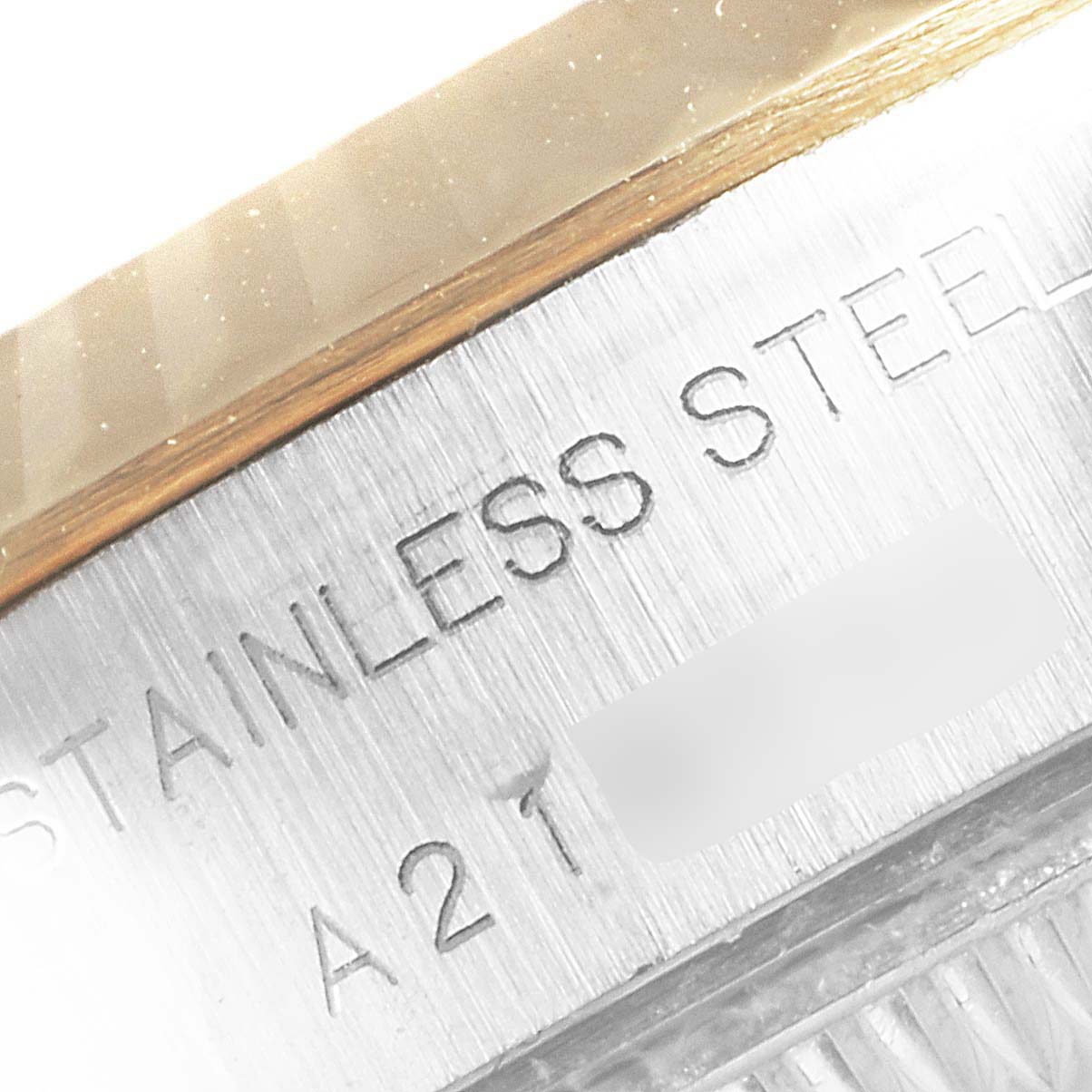 The image shows a close-up of the case back and edge inscription on the Rolex Datejust 79173 Women's Steel and Gold (two tone) Blue Dial 79173 Women's Steel and Gold (two tone) Blue Dial watch, indicating "STAINLESS STEEL" and part of the serial number.