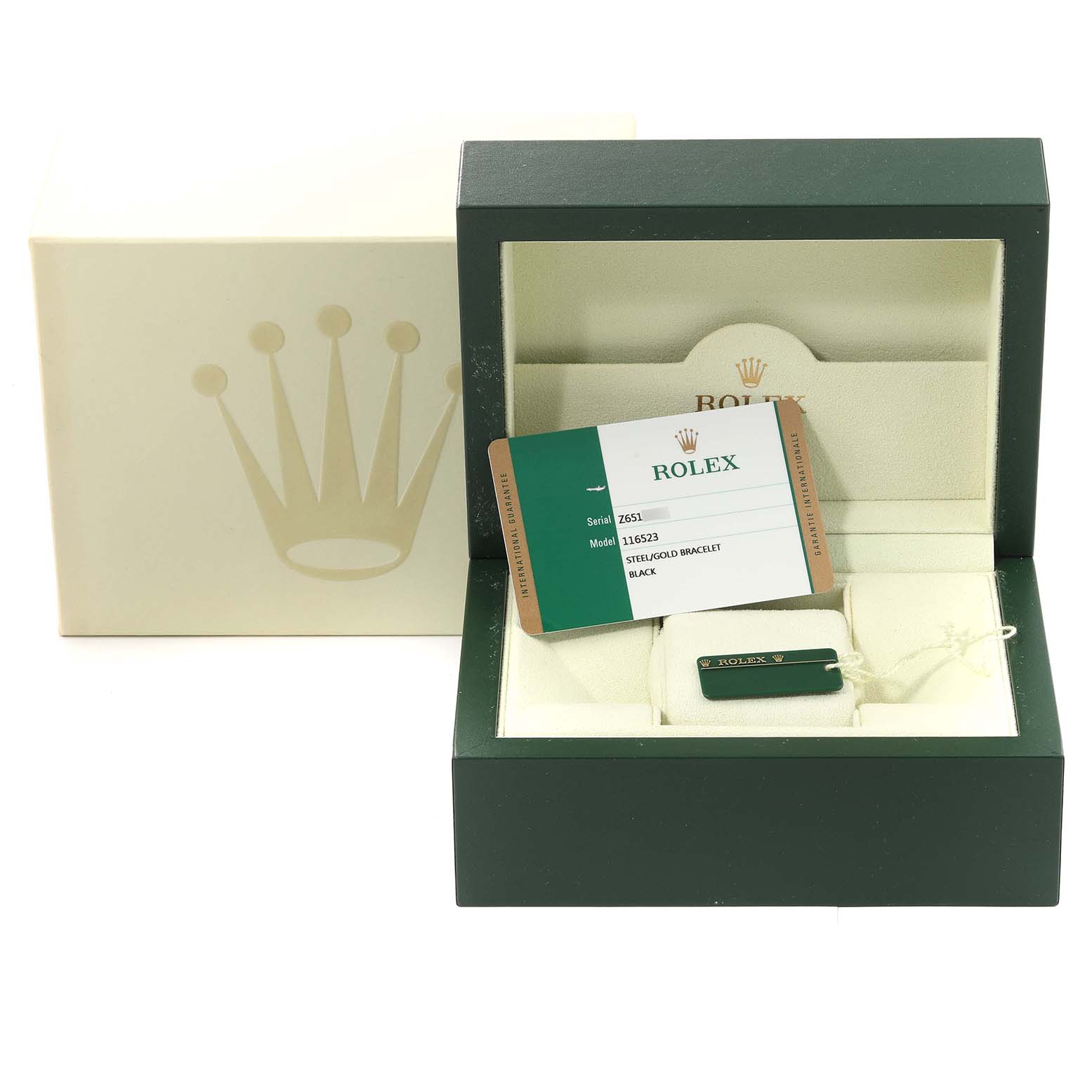 This image displays the packaging, guarantee card, and tag of a Rolex Daytona 116523 Men's Steel and Gold (two tone) Black Dial 116523 Men's Steel and Gold (two tone) Black Dial watch.