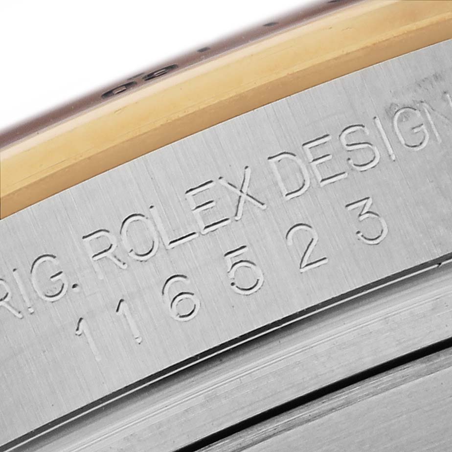 This is a close-up of the serial number and inscription on the side of a Rolex Daytona 116523 Men's Steel and Gold (two tone) Black Dial 116523 Men's Steel and Gold (two tone) Black Dial watch case.