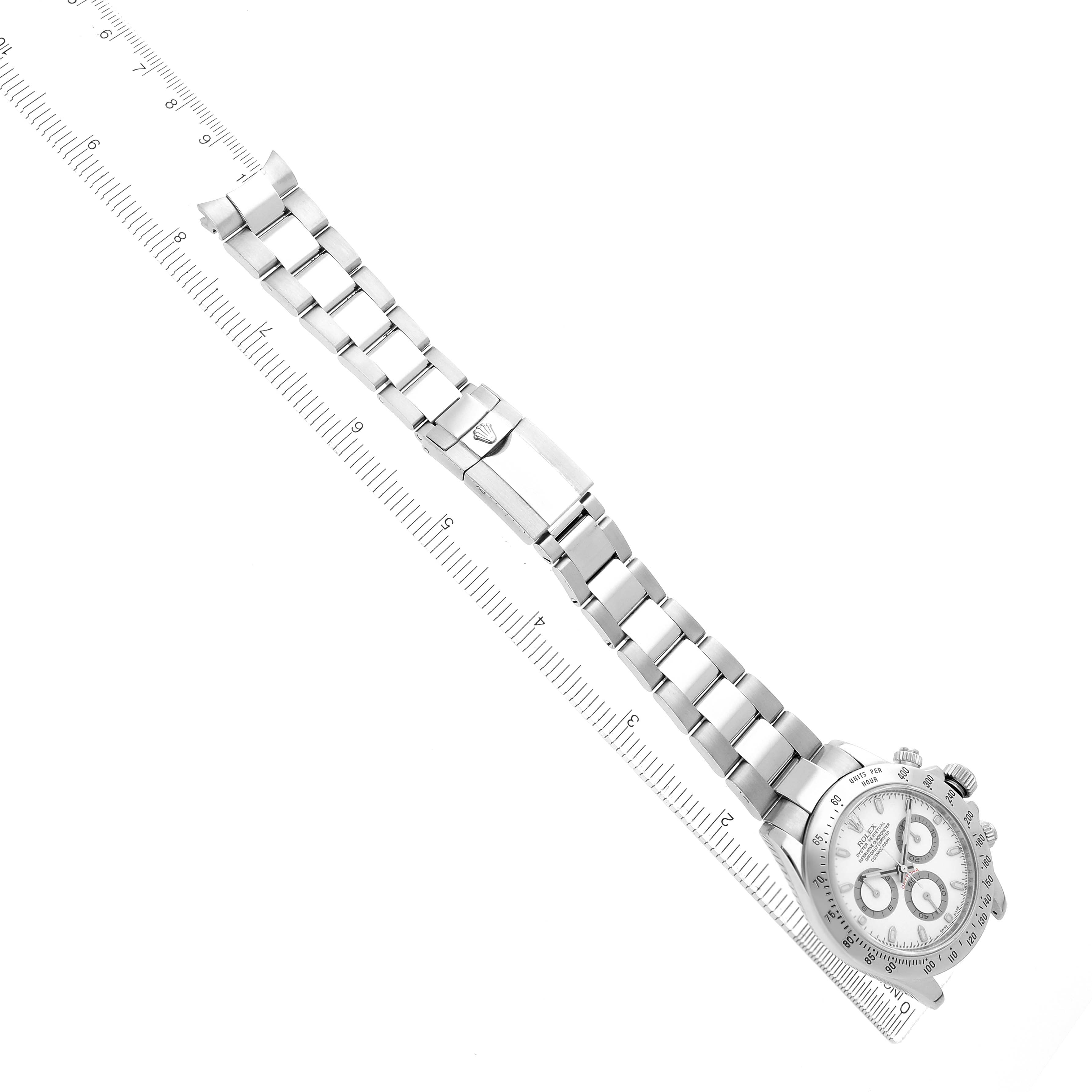 The image shows a top-down view of a Rolex Daytona 116520 Men's Stainless Steel White Dial watch with its metal bracelet aligned next to a ruler.
