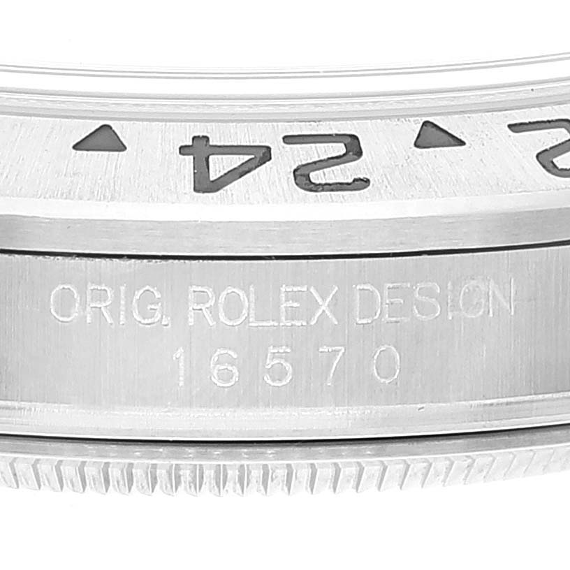 The image shows a close-up of the bezel and case side of the Rolex Explorer 16570 Men
s Stainless Steel White Dial 16570 Men
s Stainless Steel White Dial model, highlighting the engraved text "ORIG. ROLEX DESIGN 16570".