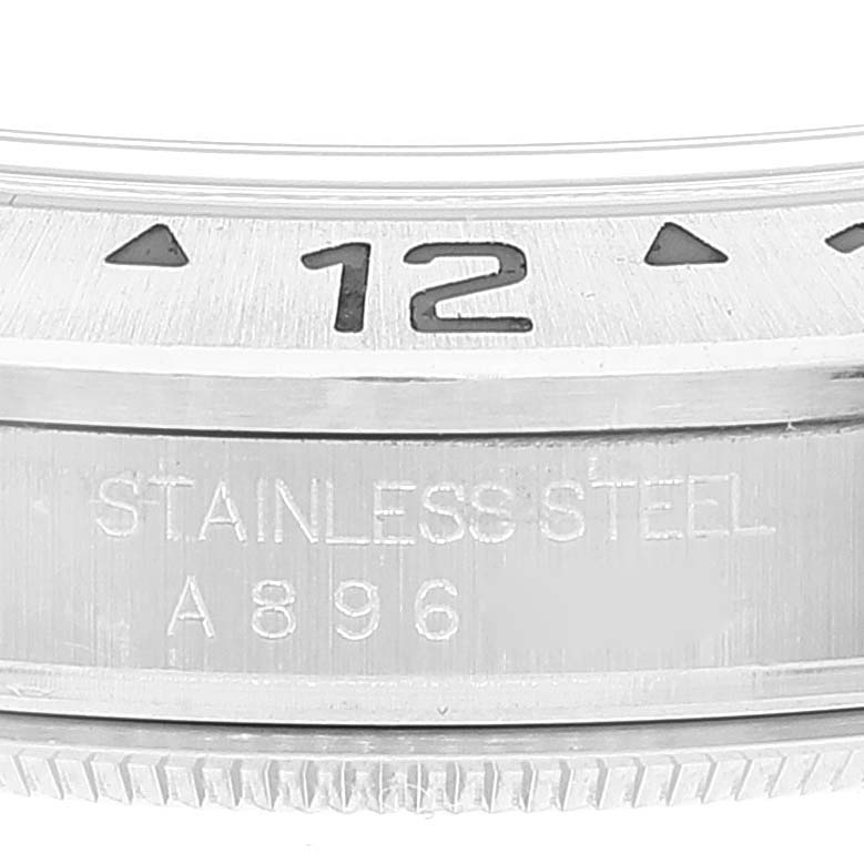 The image shows a close-up of the bezel and case of a Rolex Explorer 16570 Men
s Stainless Steel White Dial 16570 Men
s Stainless Steel White Dial watch, featuring the 12 o
clock marker and "STAINLESS STEEL" engraving.