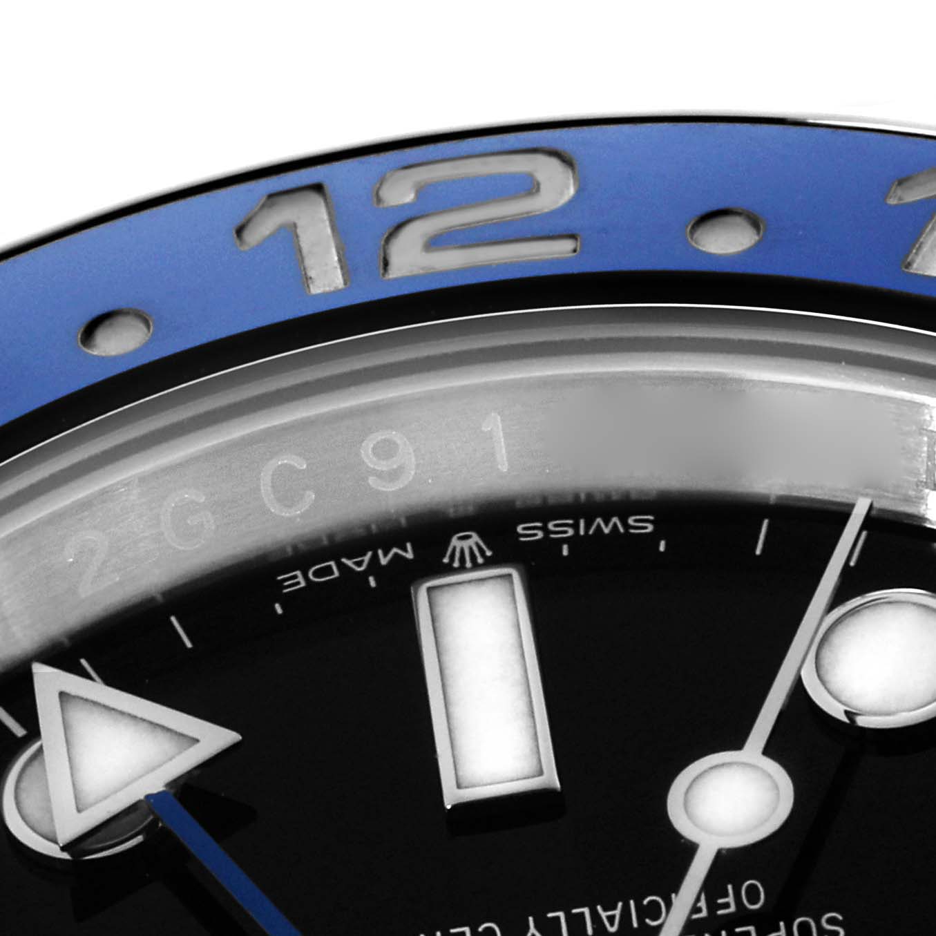 The image shows a close-up of the bezel and dial of a Rolex GMT-Master 126710 Men
s Stainless Steel Black Dial, highlighting the 12 marker and part of the watch face.
