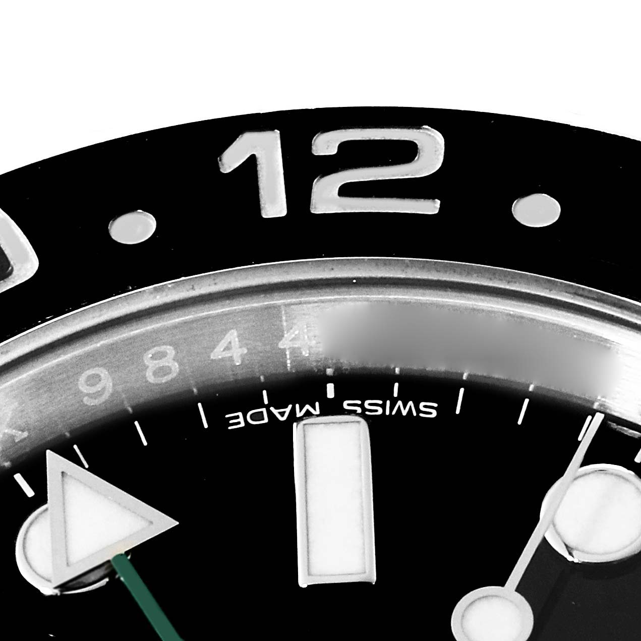 This close-up image of the Rolex GMT-Master 116710 Men's Stainless Steel Black Dial 116710 Men's Stainless Steel Black Dial model shows the bezel, "12" marker, part of the dial, and partial hour and seconds hands.