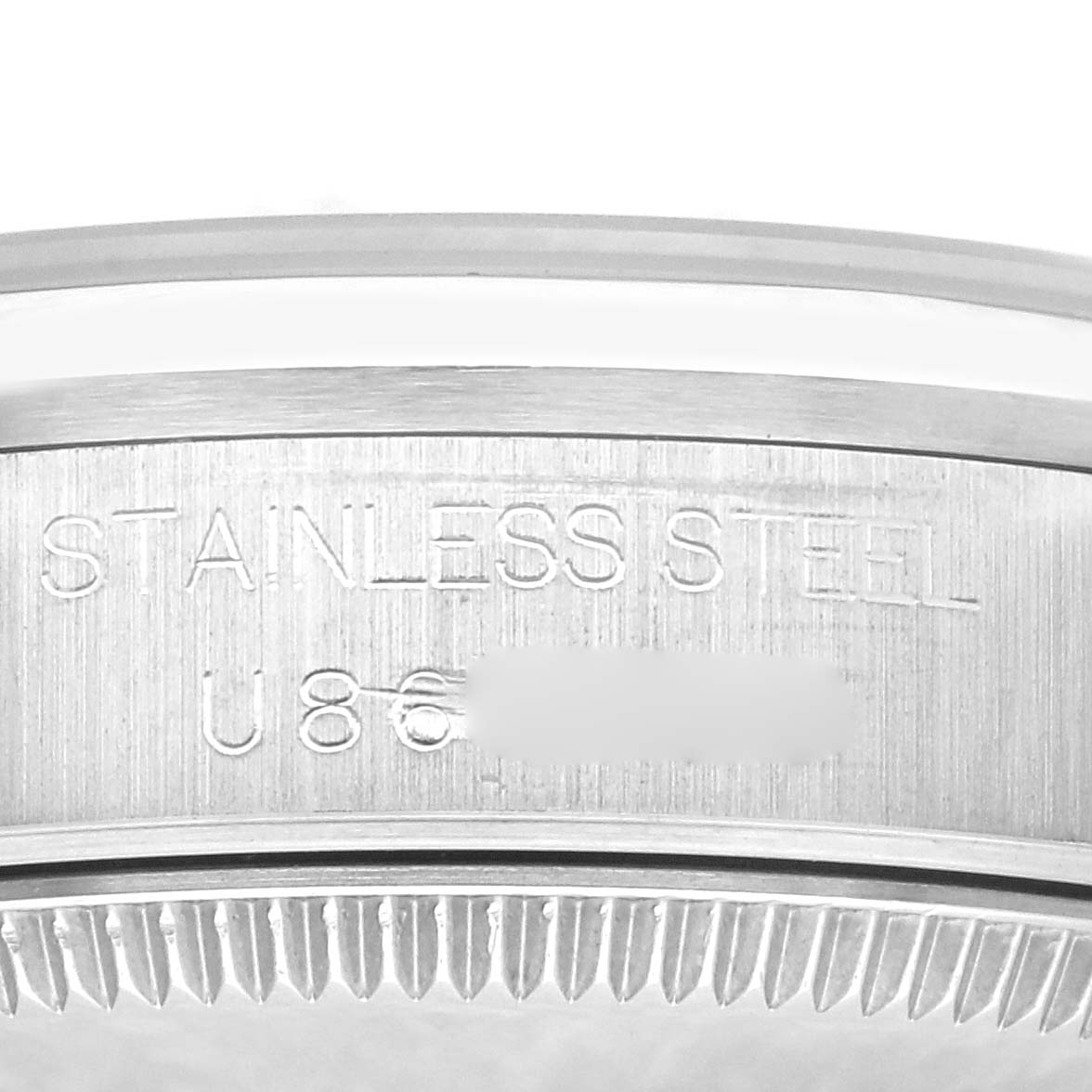 The image shows a close-up of the case back of a Mid-Size Rolex watch, highlighting the "STAINLESS STEEL" engraving and partial serial number.