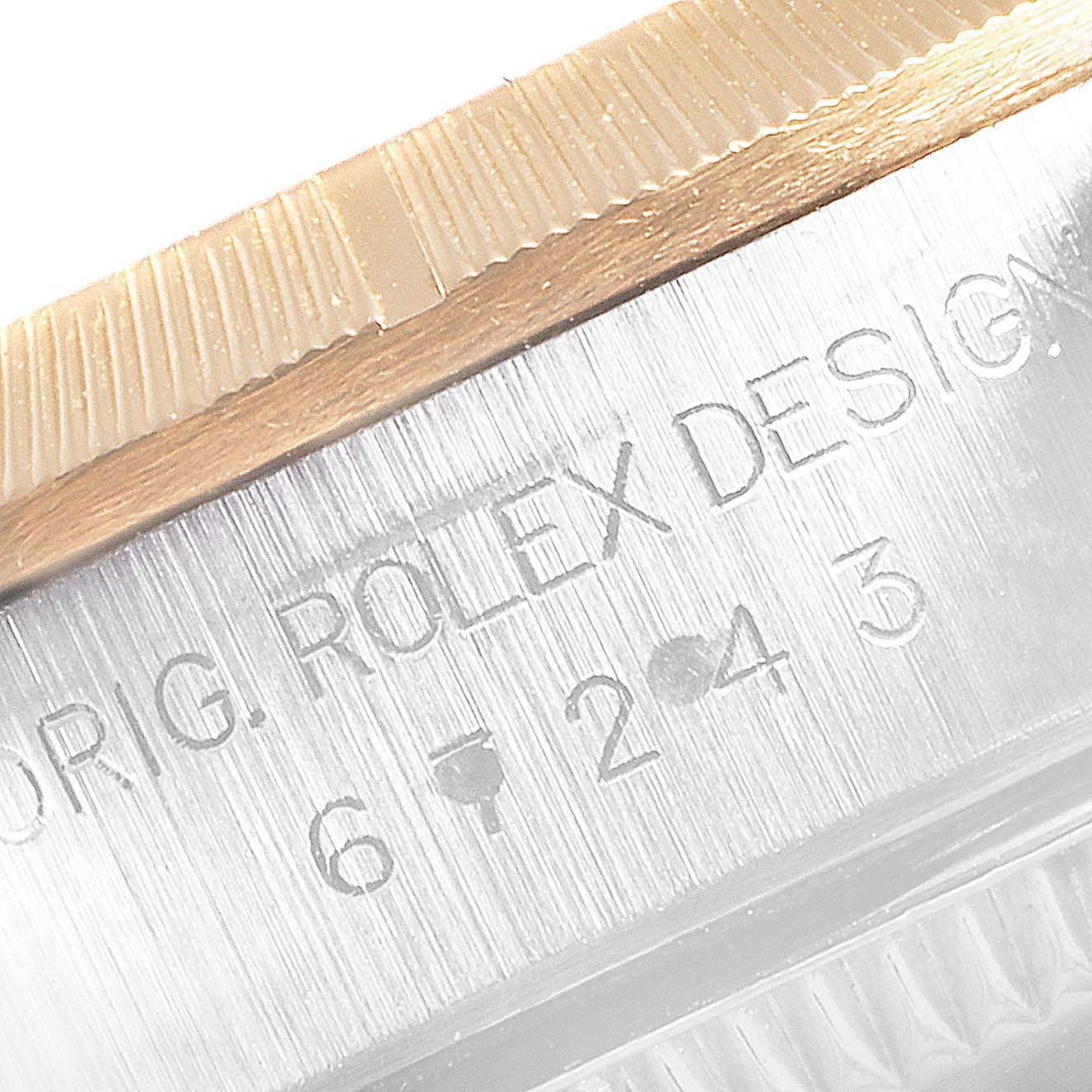 The image shows a close-up of the serial number engraving and the fluted bezel of a Rolex Datejust 67243 Women's Steel and Gold (two tone) White Dial 67243 Women's Steel and Gold (two tone) White Dial watch.