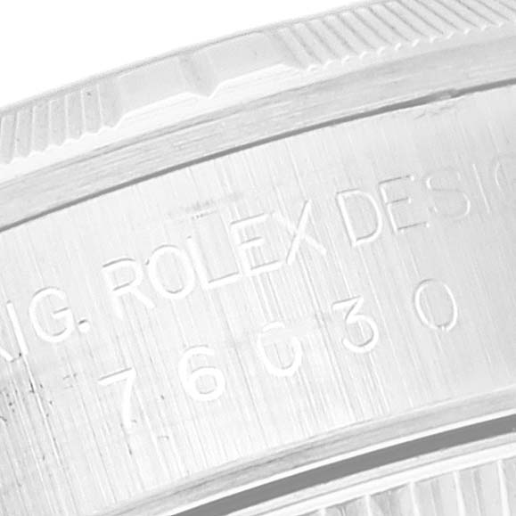 The image shows a close-up side view of the bezel and case back of the Rolex Oyster Perpetual 76030 Women's Stainless Steel Pink Dial 76030 Women's Stainless Steel Pink Dial watch, displaying engraved text.