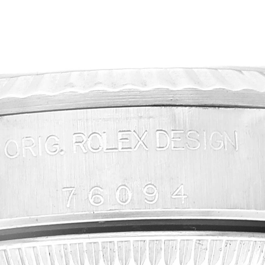 This image shows a close-up of the engraving on the side of the bezel of a Rolex Oyster Perpetual 76094 Women's Stainless Steel Black Dial 76094 Women's Stainless Steel Black Dial watch.