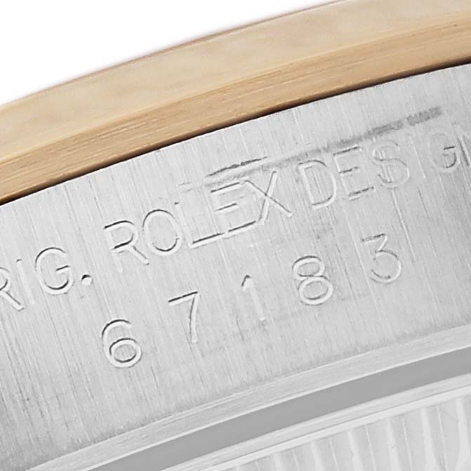 The image shows a close-up of the engraved back case of the Rolex Oyster Perpetual 67183 Women's Steel and Gold (two tone) Silver Dial 67183 Women's Steel and Gold (two tone) Silver Dial watch, highlighting design details.