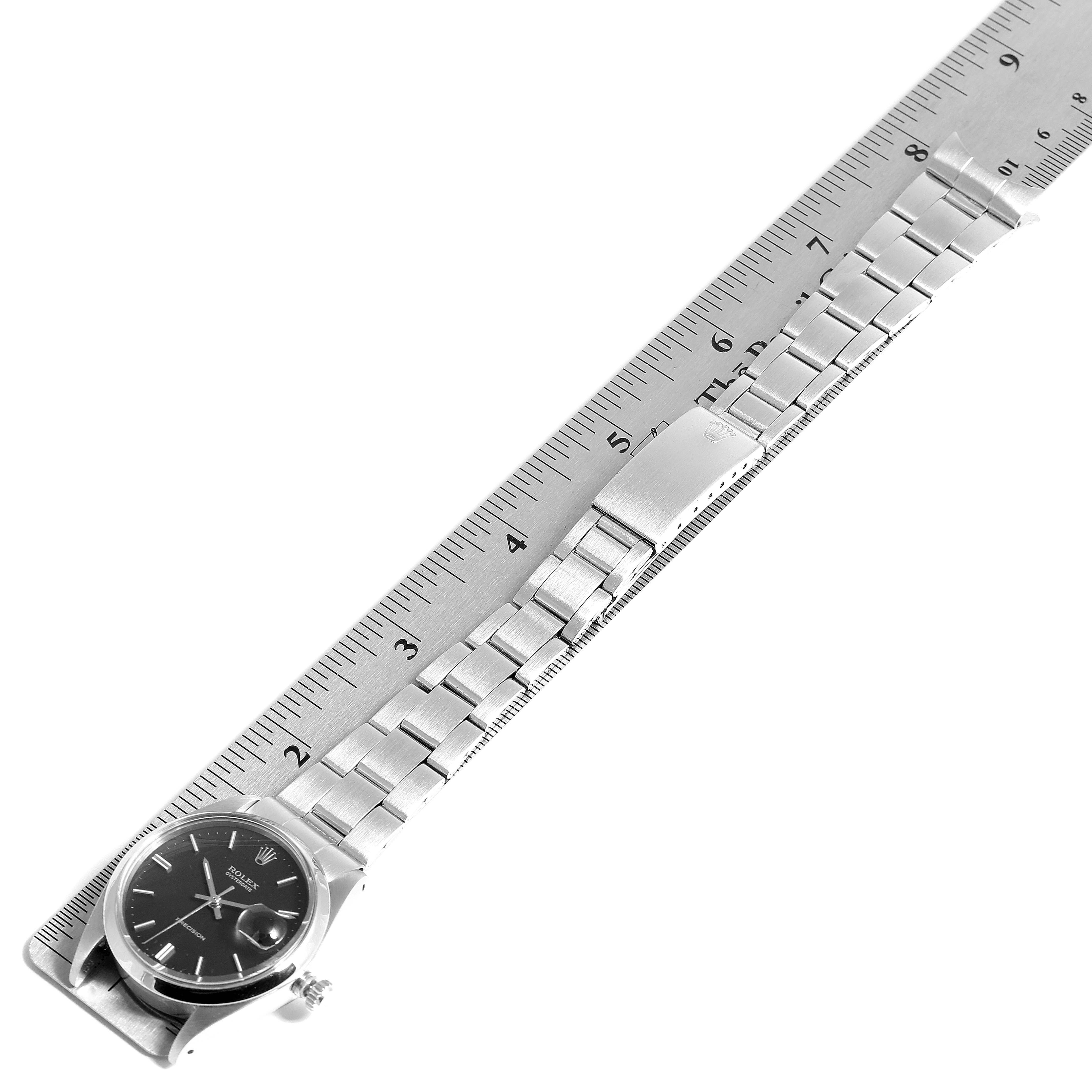 The Rolex Vintage Collection 6694 Men's Stainless Steel Black Dial 6694 Men's Stainless Steel Black Dial watch is displayed in full, measured against a ruler, showing its face, bracelet, and clasp.