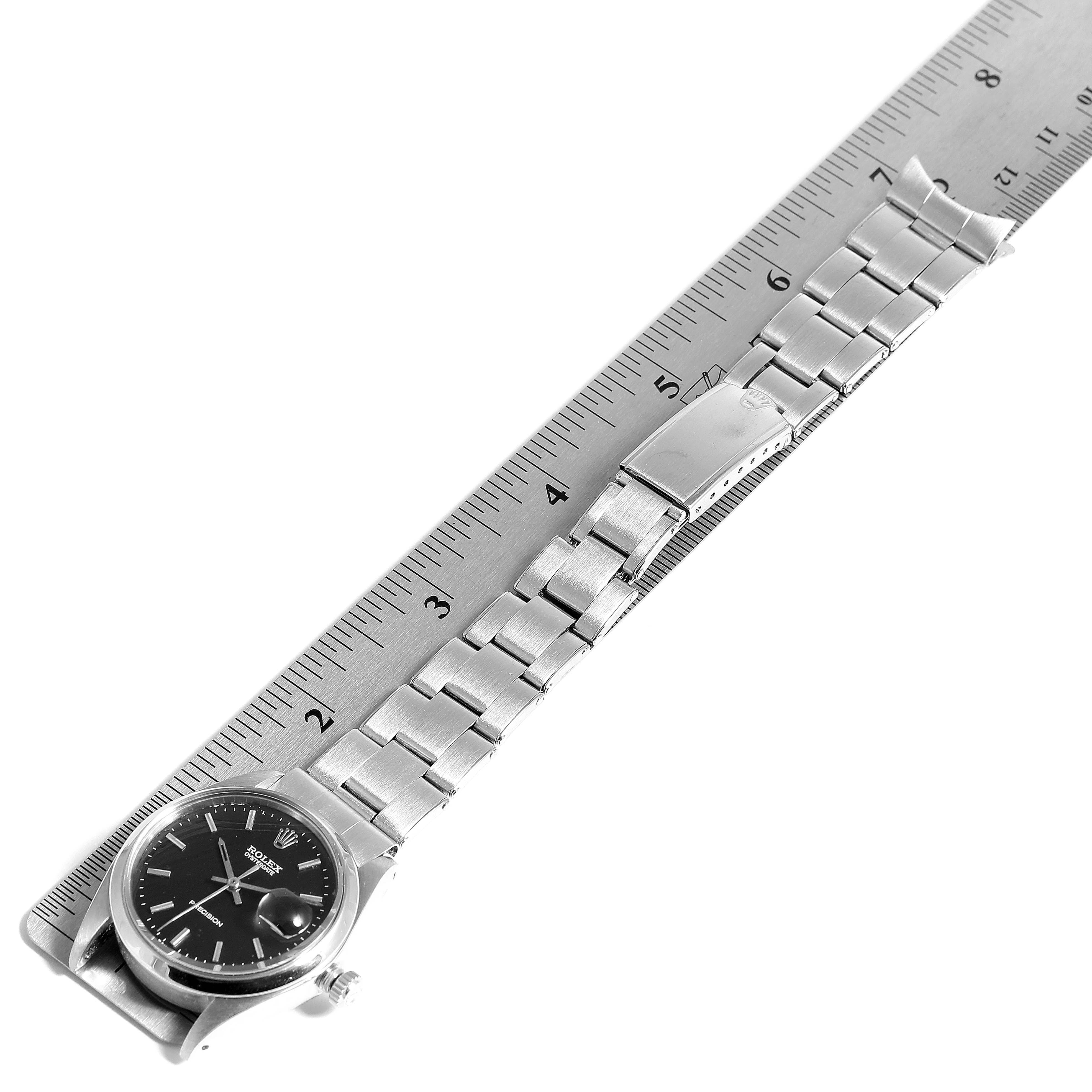 The image shows a Rolex Vintage Collection 6694 Men's Stainless Steel Black Dial 6694 Men's Stainless Steel Black Dial watch laid flat on a ruler, highlighting its full bracelet and clasp.