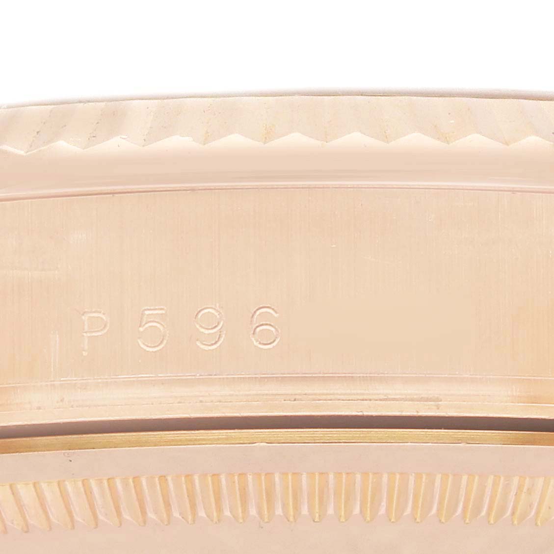 The image shows a close-up of the edge and outer case of a Rolex Date 118235 Men
s Rose Gold Silver Dial watch with engraved markings.
