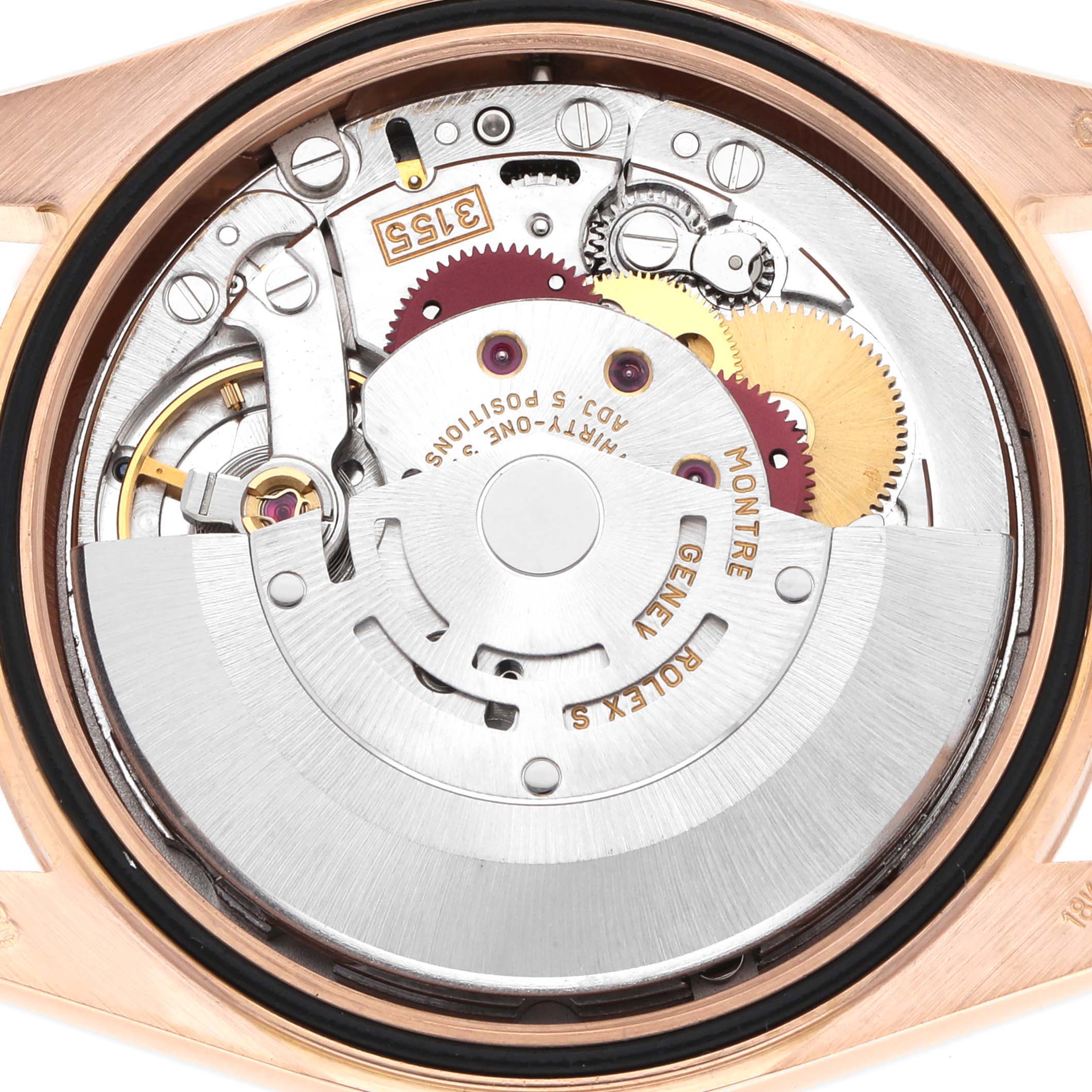 The image shows the movement of a Rolex Date 118235 Men
s Rose Gold Silver Dial model watch from the back, highlighting gears and the rotor.
