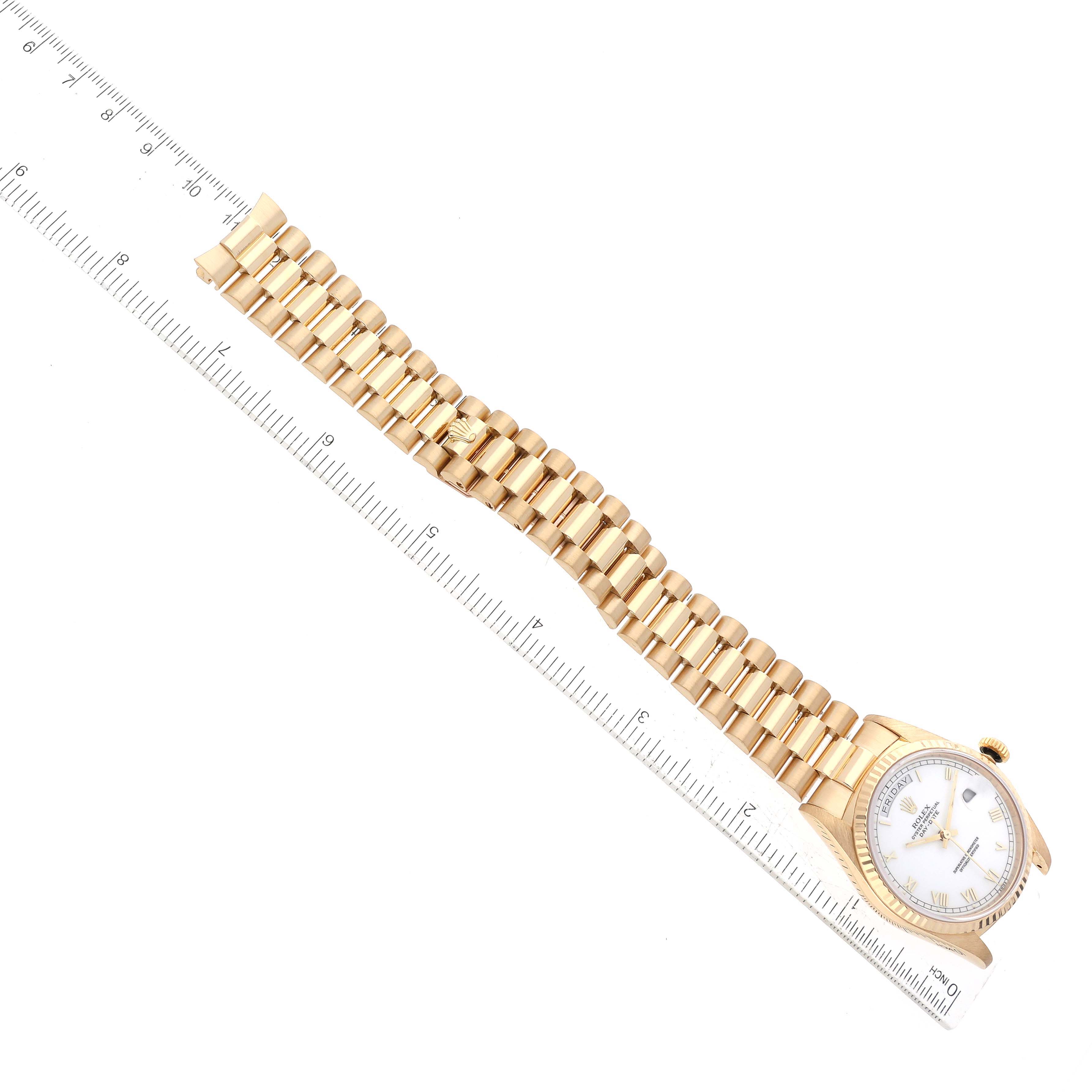 The image shows an overhead view of a Rolex President 18238 Men's Yellow Gold White Dial 18238 Men's Yellow Gold White Dial model watch alongside a ruler.