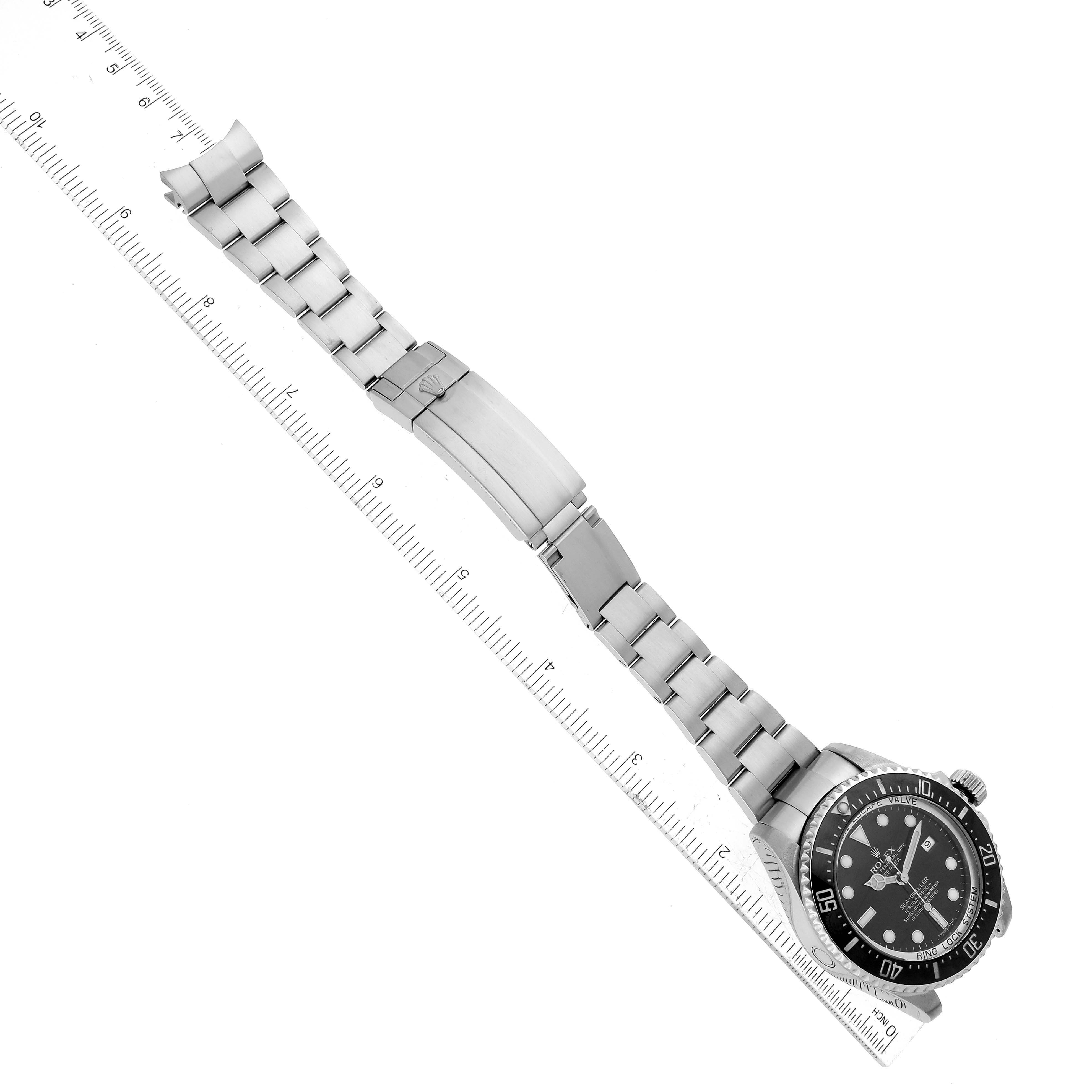 The Rolex Sea-Dweller 116660 Men's Stainless Steel Black Dial watch is shown from a top-down angle, displaying the dial, bezel, and full bracelet next to a ruler.