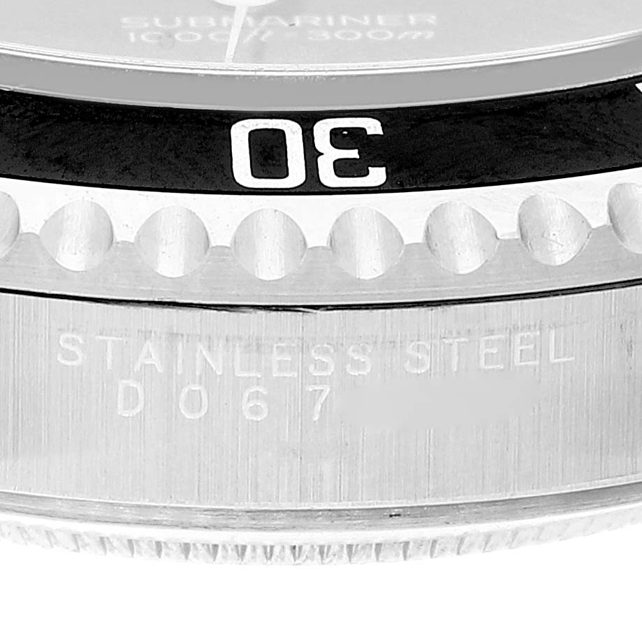 The image shows a close-up angle of the bezel and part of the case of a Rolex Submariner 14060 Men
s Stainless Steel Black Dial 14060 Men
s Stainless Steel Black Dial watch, displaying the 30-minute marker and "STAINLESS STEEL" engraving.