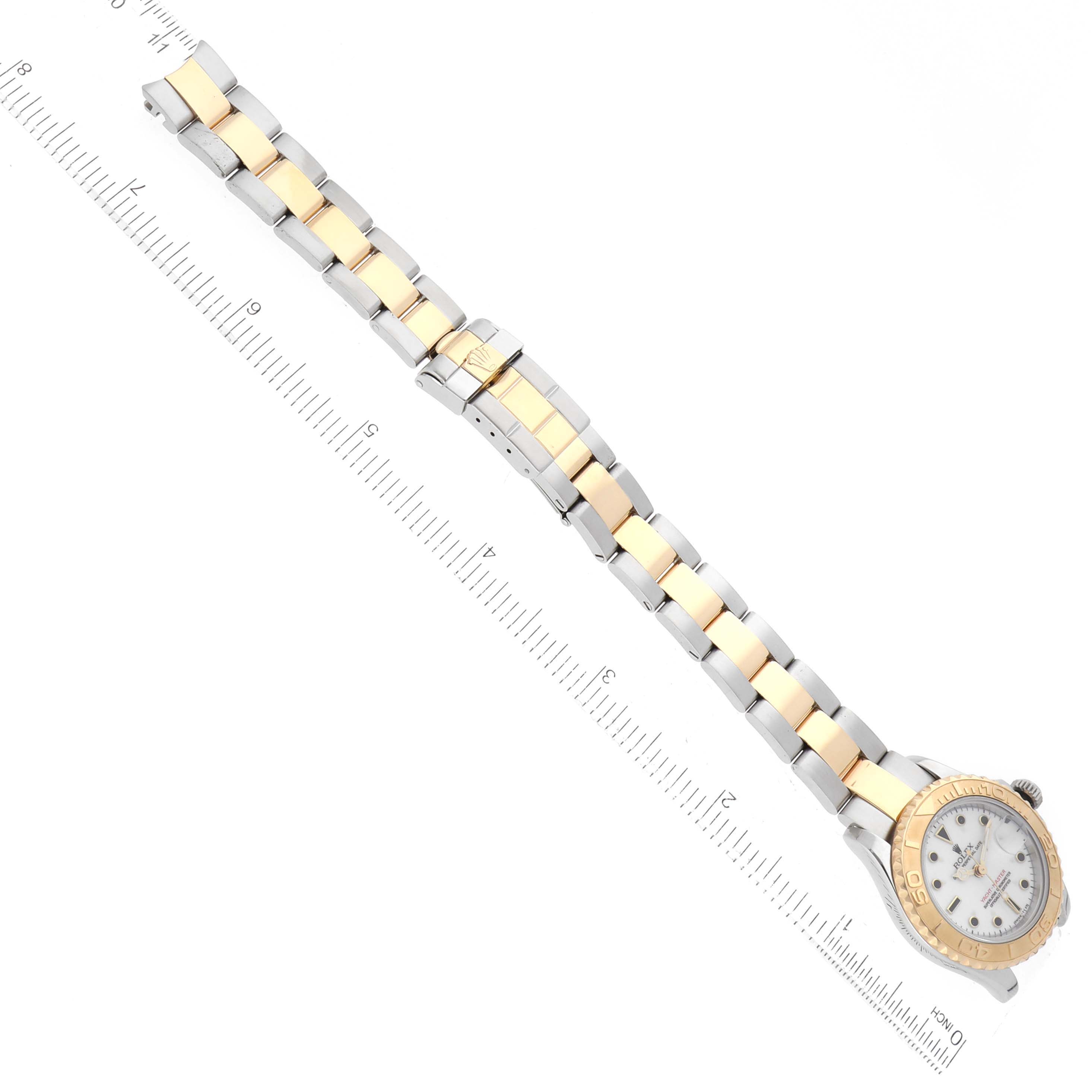 The Rolex Yacht-Master 69623 Women's Steel and Gold (two tone) White Dial 69623 Women's Steel and Gold (two tone) White Dial watch is shown from a top-down angle with its face, bezel, and full bracelet visible alongside a ruler.