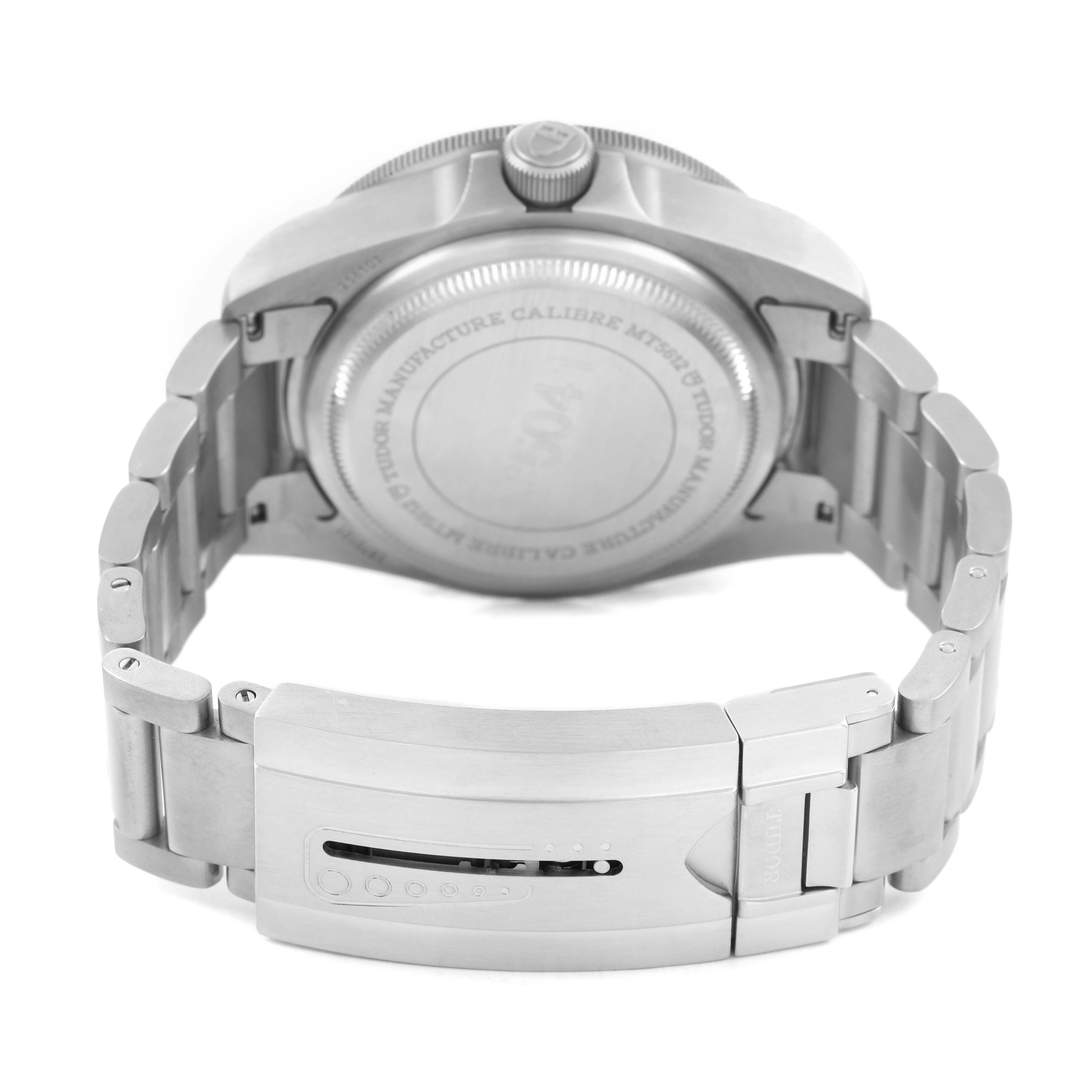 The image shows the back of a Tudor Pelagos M25610TNL-0001 Men's Titanium Black Dial watch, highlighting its case back, clasp, and metal bracelet from the rear angle.