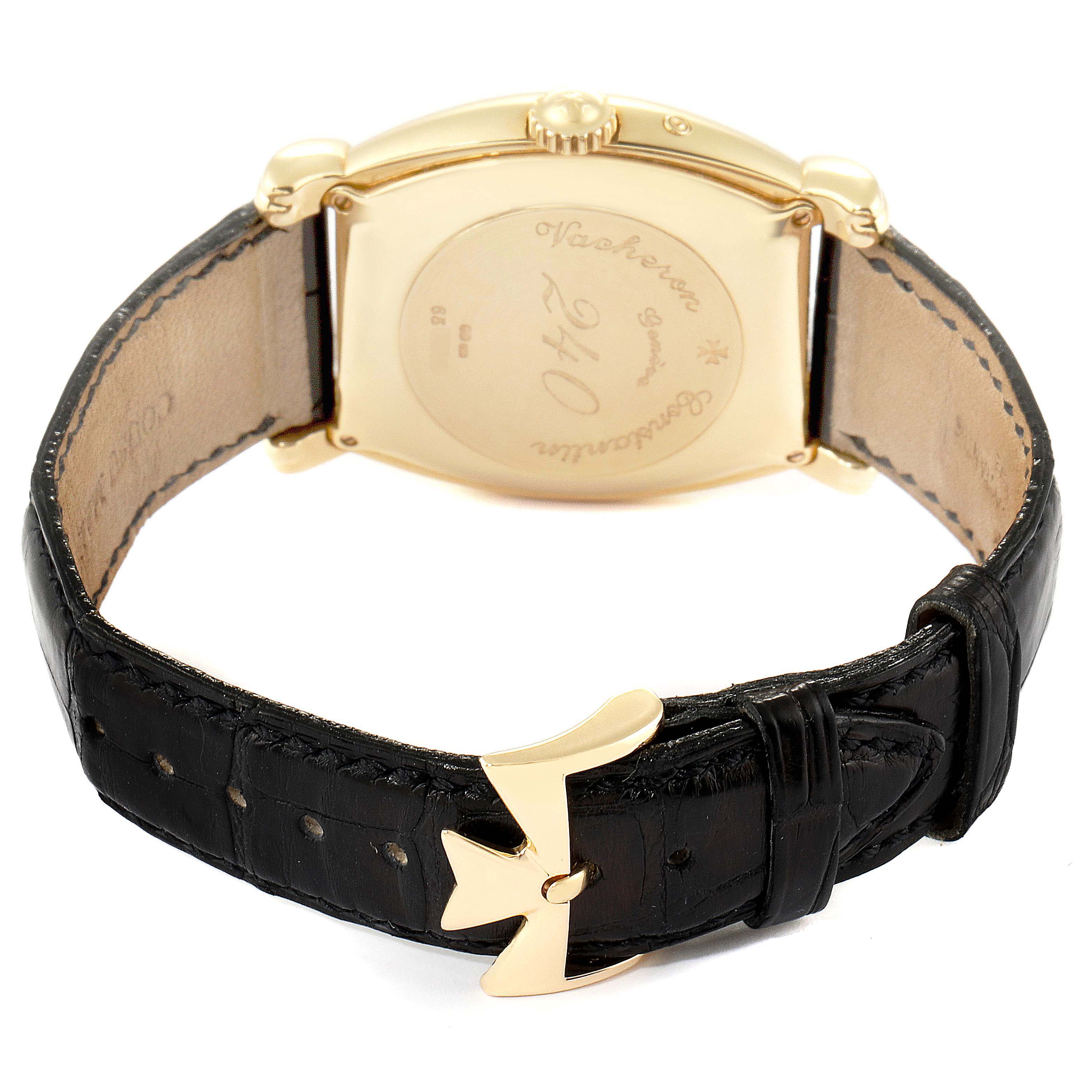 The image shows the back of the Vacheron Constantin Vintage 47240 Men's Yellow Gold Silver Dial 47240 Men's Yellow Gold Silver Dial watch, highlighting its gold casing, inscription, and black leather strap.