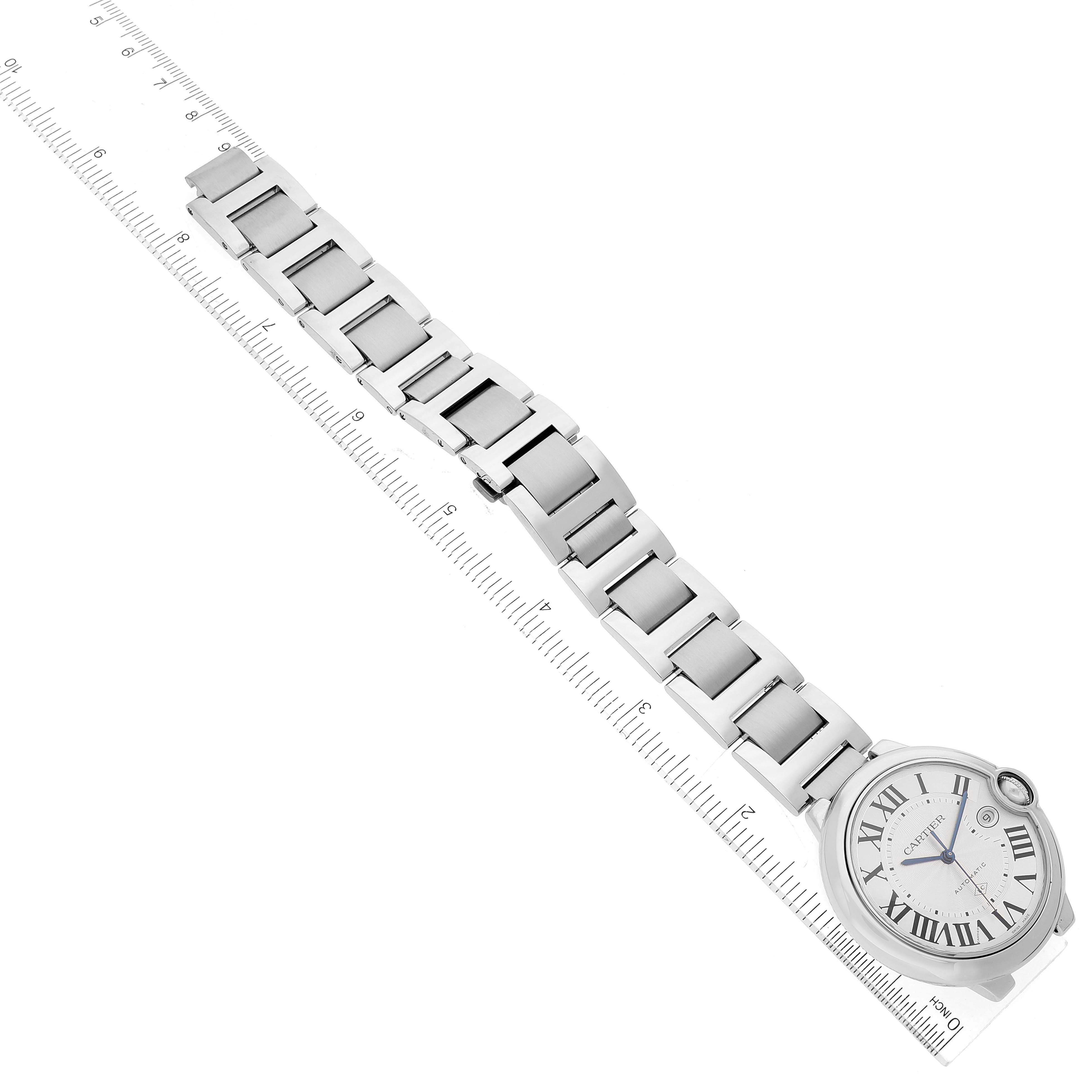 The image shows the top view of a Cartier Ballon Bleu W6920094 Men's Stainless Steel Silver Dial W6920094 Men's Stainless Steel Silver Dial watch with its full bracelet extended next to a ruler for measurement.