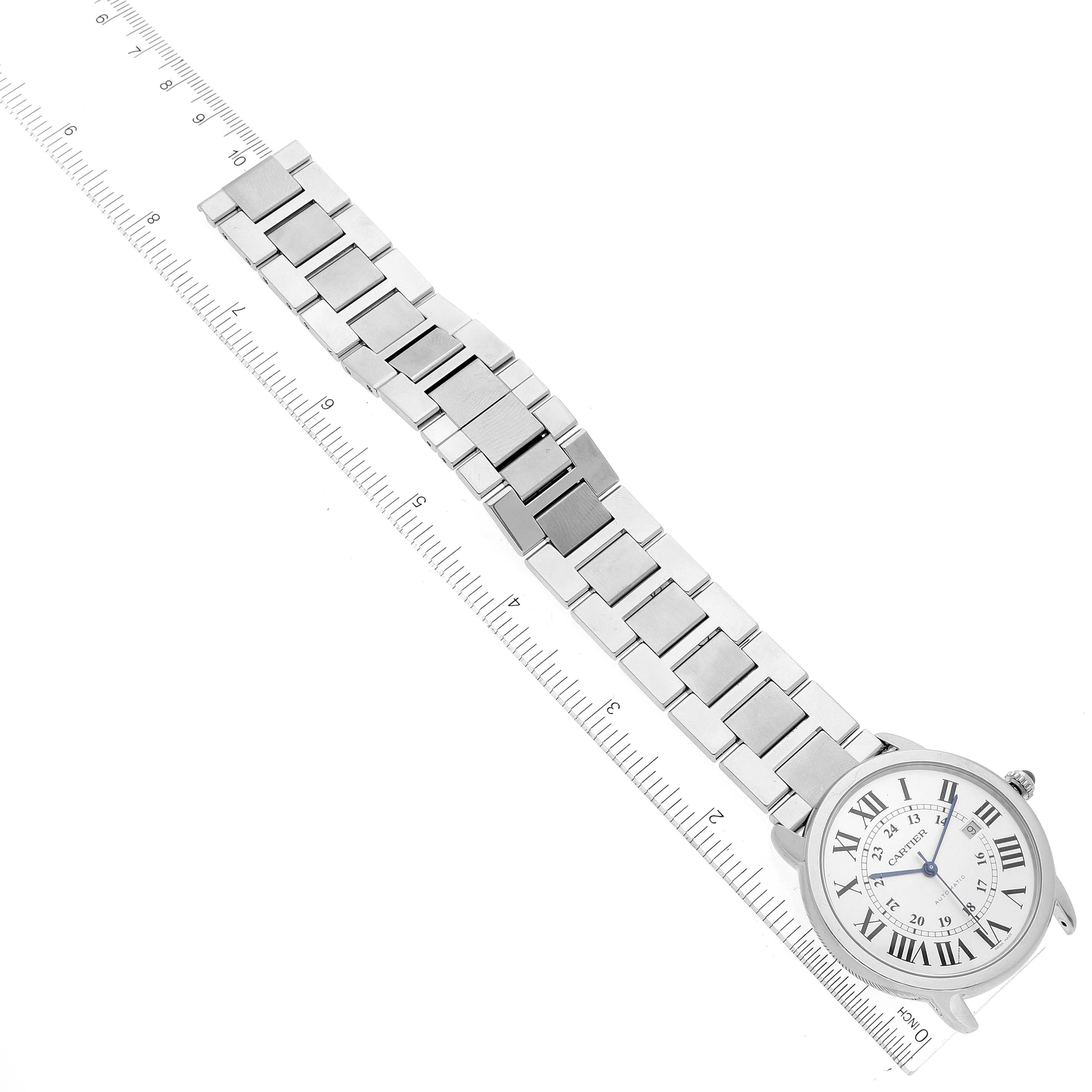 The image shows a Cartier Ronde W6701011 Men
s Stainless Steel Silver Dial W6701011 Men
s Stainless Steel Silver Dial watch laid flat on a ruler, highlighting the face and metal bracelet.