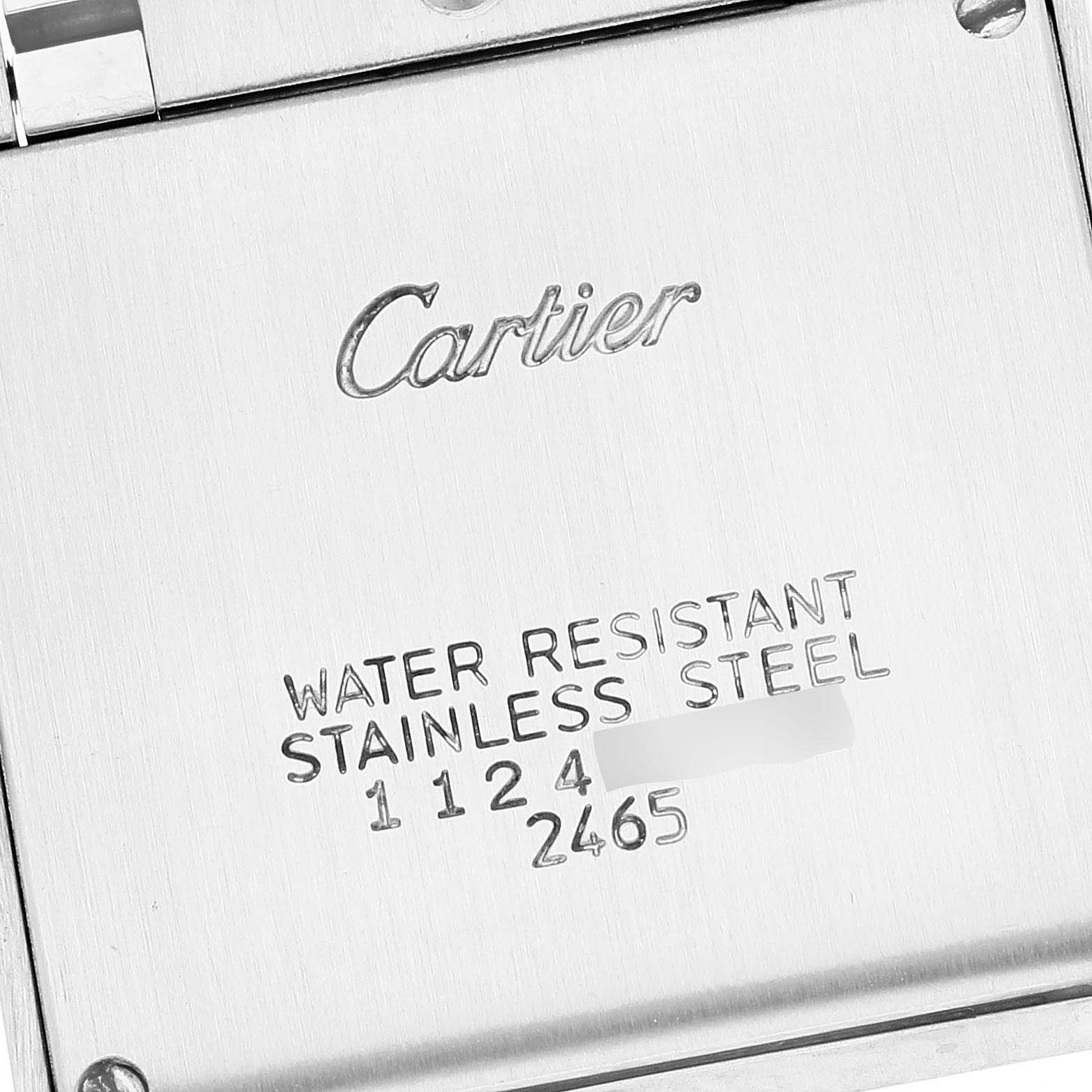 The image shows the back case of a Cartier Tank Française watch with engravings detailing water resistance and material.