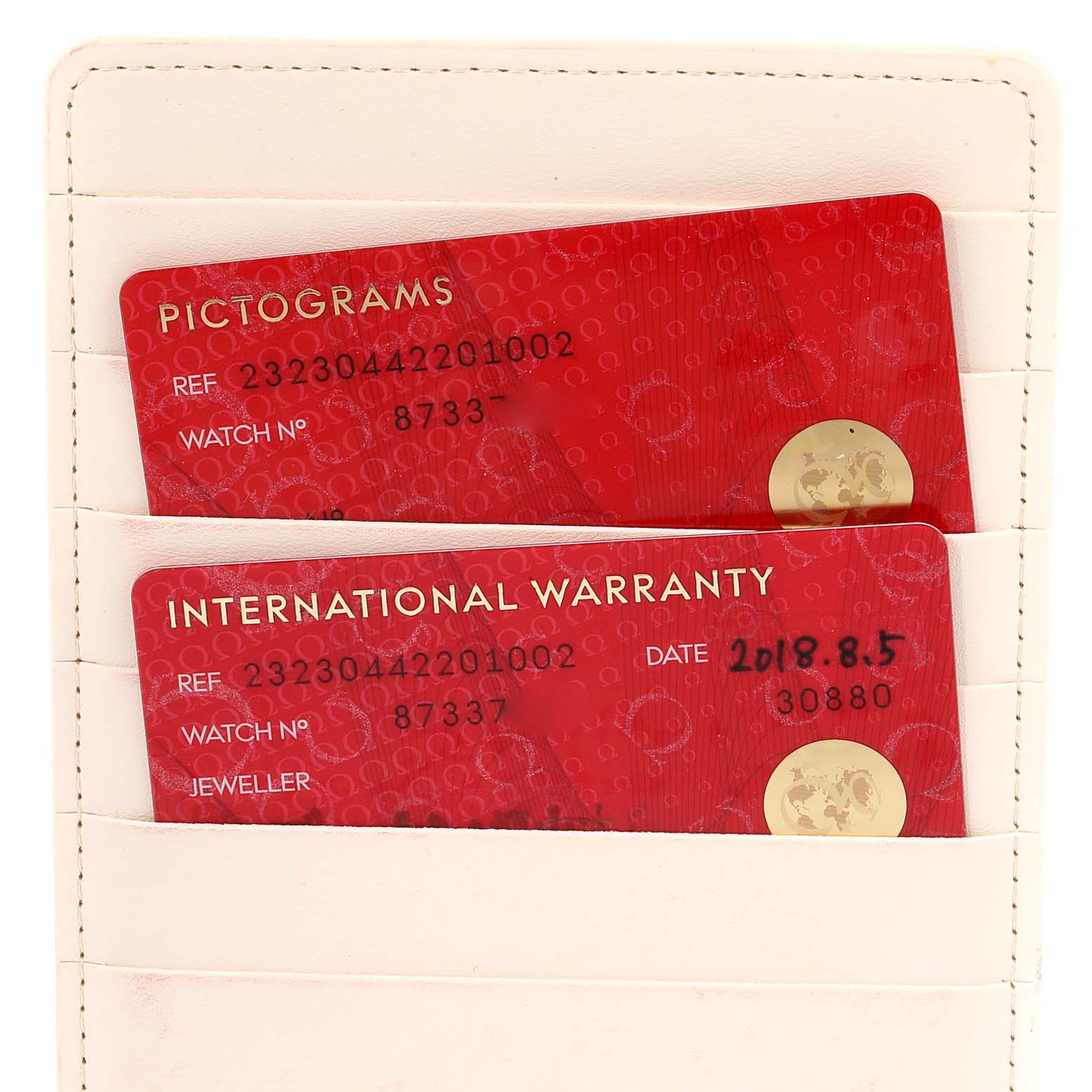 The image shows warranty and pictogram cards for the Omega Planet Ocean 232.30.44.22.01.002 Men's Stainless Steel Black Dial 232.30.44.22.01.002 Men's Stainless Steel Black Dial model, displayed in a white cardholder.