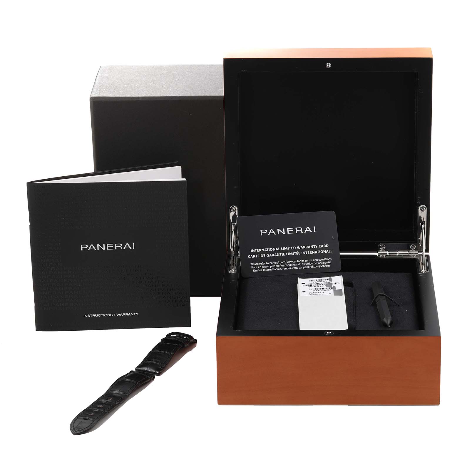 The image shows a Panerai Luminor PAM01272 Men's Stainless Steel Black Dial PAM01272 Men's Stainless Steel Black Dial watch box with an instruction manual, warranty card, and an extra strap displayed at a front angle.